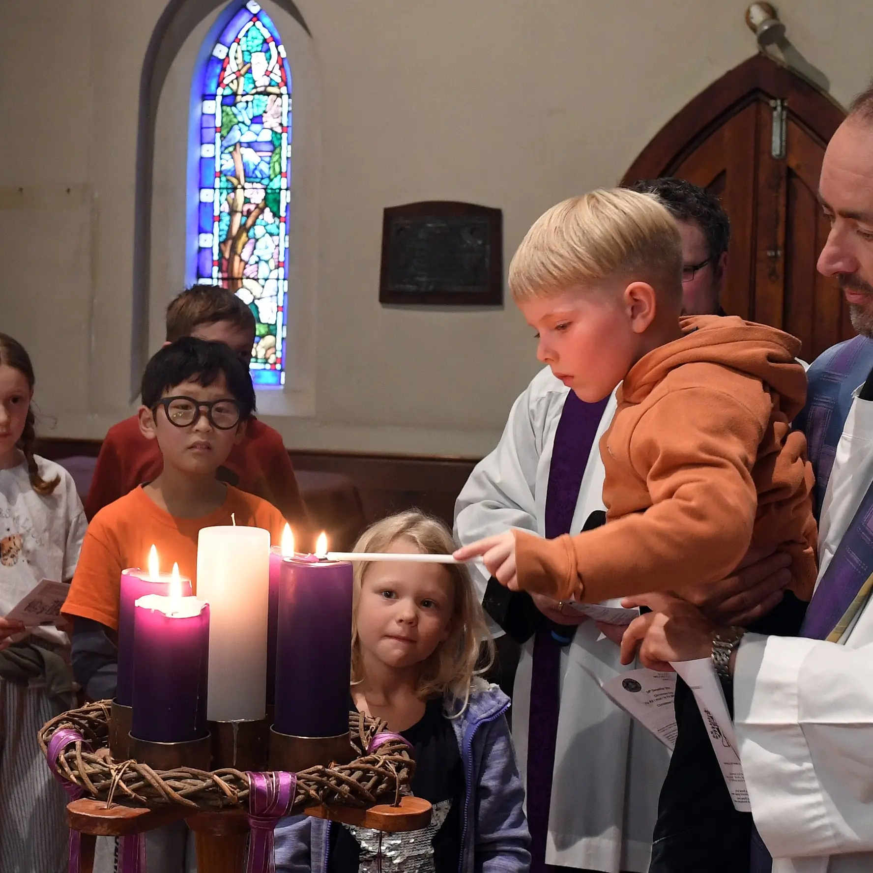 Children place figurines into manger