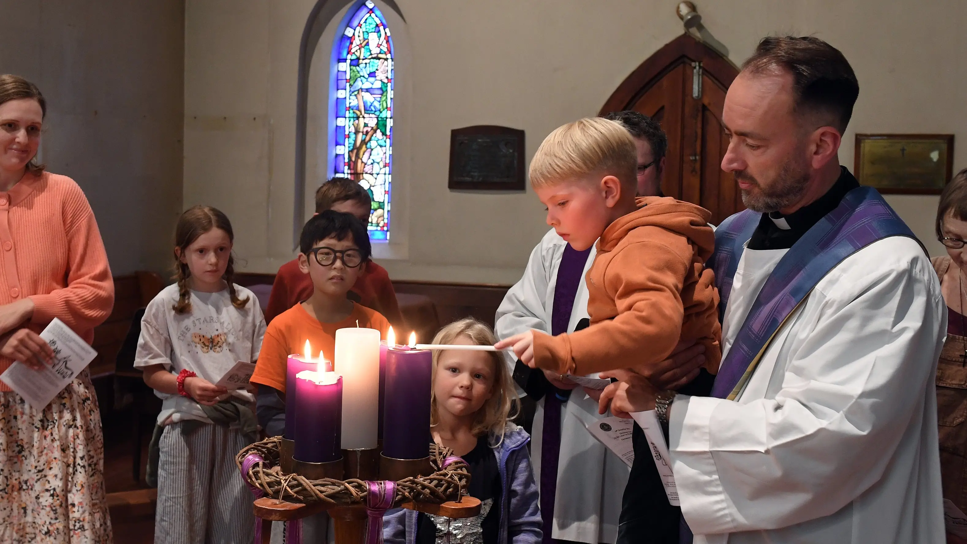Children place figurines into manger