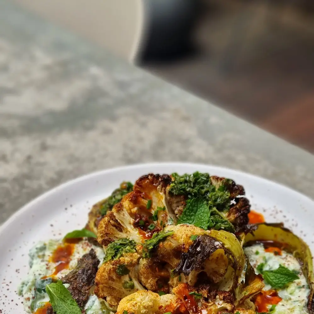 Turkish roasted cauliflower with coconut raita, fresh herbs and chilli oil