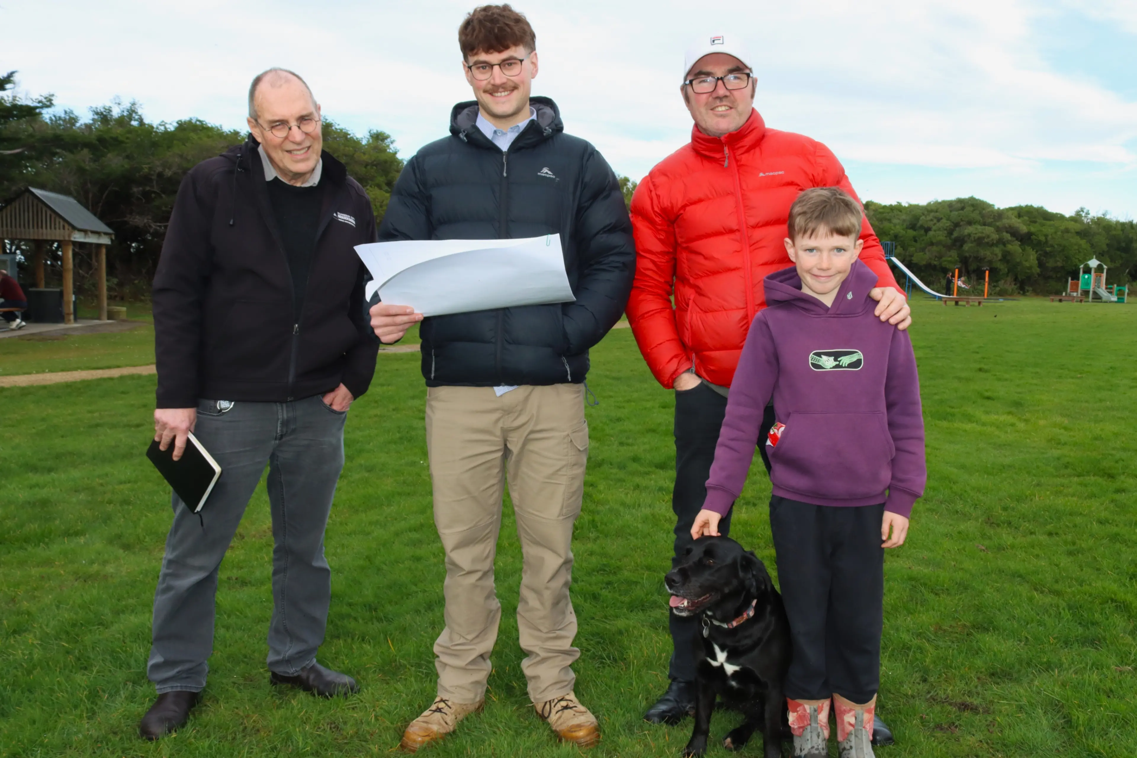 Checking draft plans for a new pump track at Brighton Domain are (from left) Dunedin City Council parks planning manager John Brinkley, SouthRoads civil cadet Jack Hadland, Brighton pump track steering committee member Shane Turner, his son, Zach Turner, 10, and their dog, Zoey. Photo: Sam Henderson