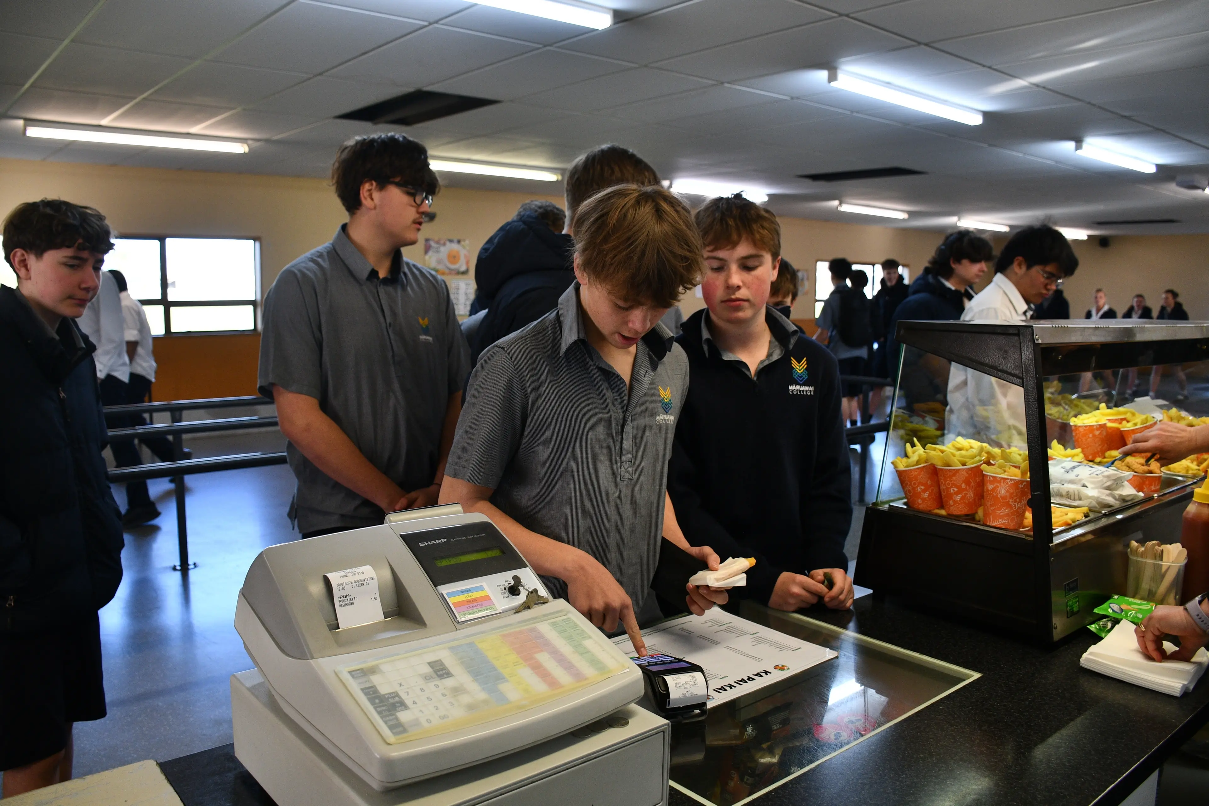 M\\u0101ruawai College\\'s canteen proved popular as it re-opened at the school\\'s Monday morning break, students Hunter Mackey, 14, (left) purchases a hash brown next to another keen customer, Marshall Sinclair, 15, (right). Photo: Gemma Sinclair