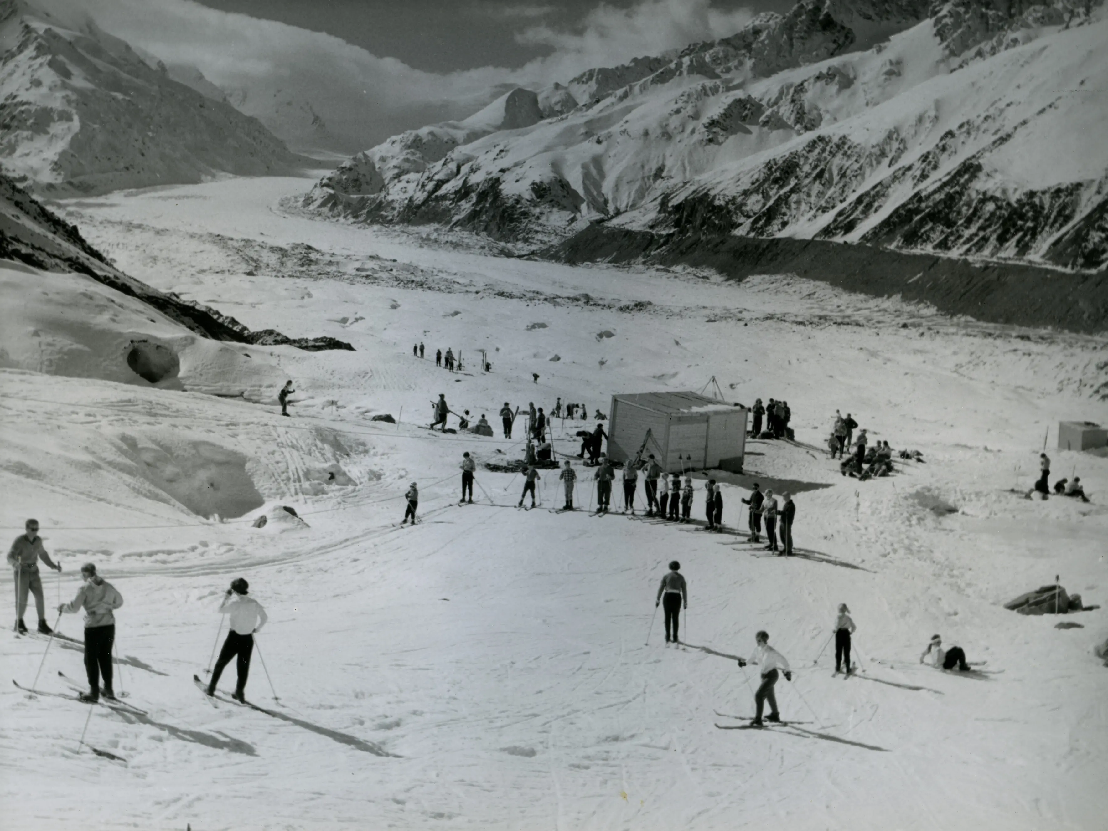 Skiers using a rope tow installed on the Ball Glacier in the late 1950s, with Tasman Glacier in the background. Photo: South Canterbury Museum