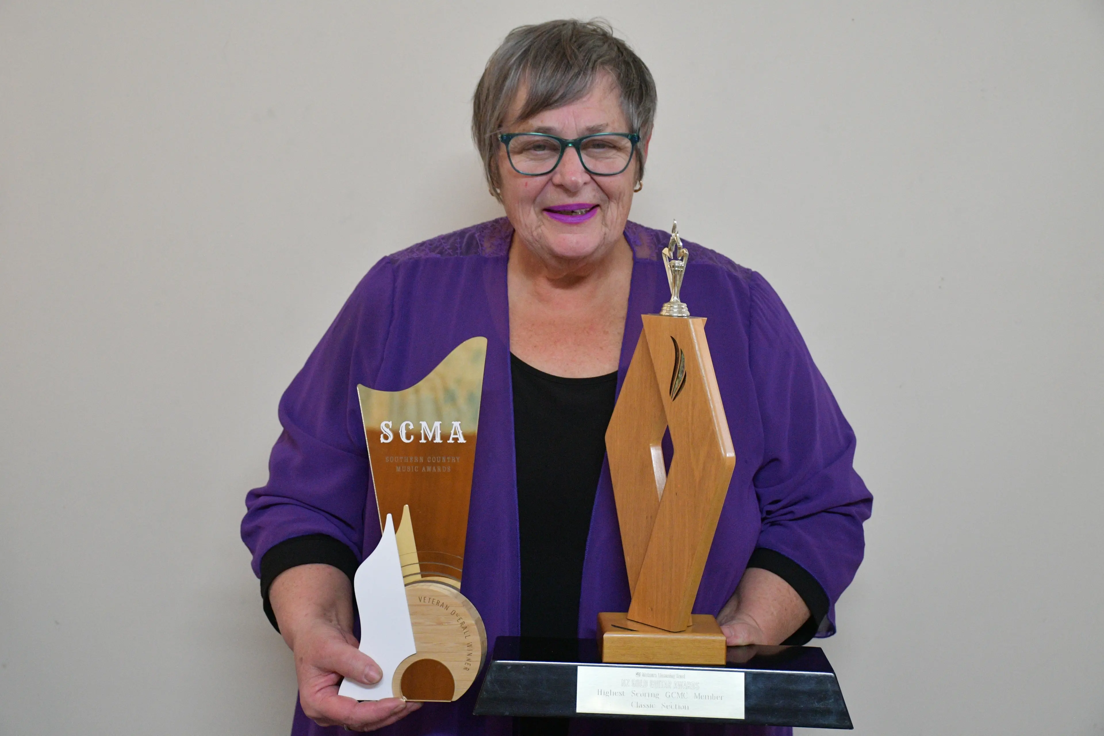 Heather Thacker holds two of her crown jewels, her overall veteran winner trophy from the Southern Country Music Awards in Otago two weeks ago and her New Zealand Gold Guitar Award, in the classic section, she earned in May. Photo: Gemma Sinclair