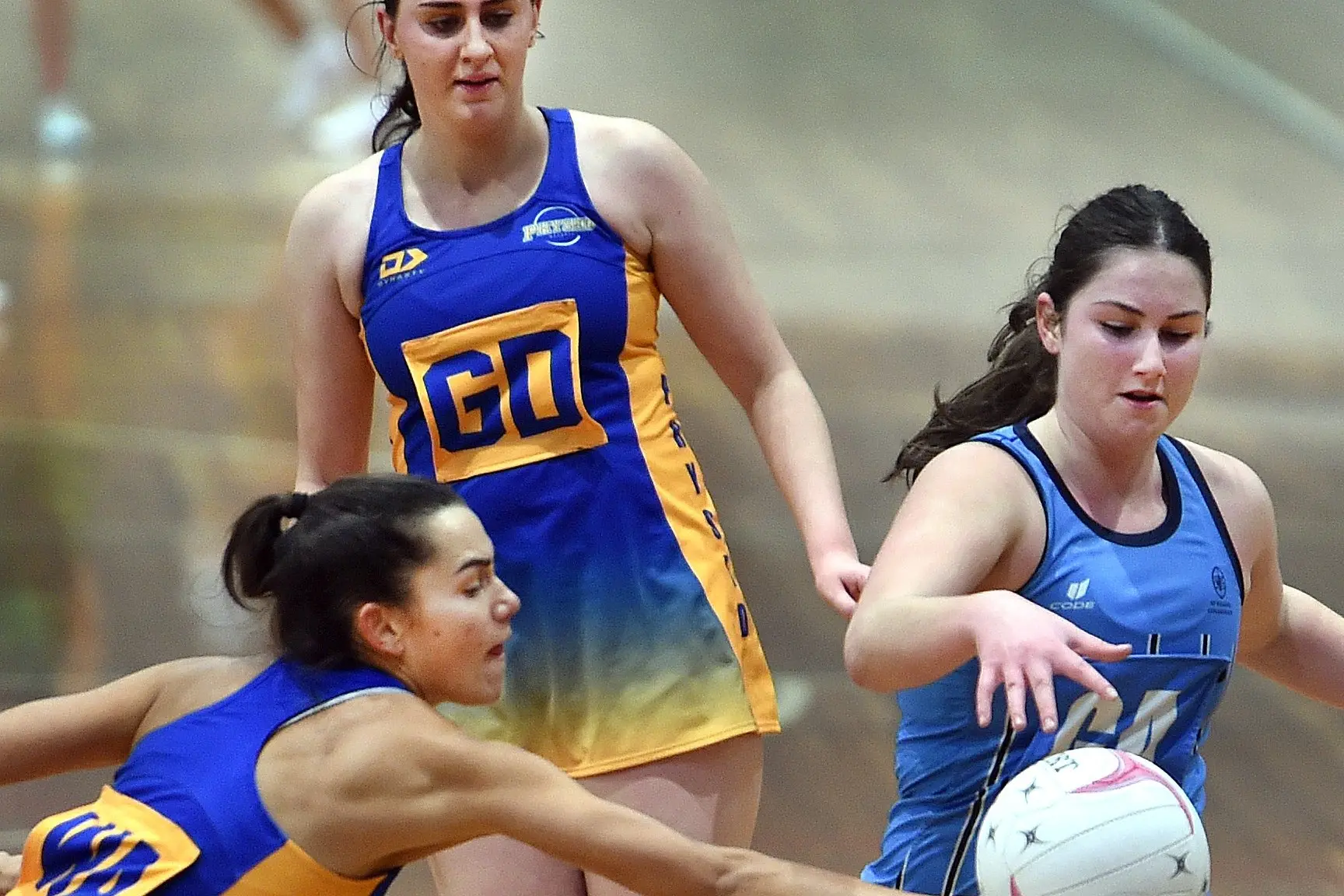 Physed A wing attack Gemma Rowcroft (left) and St Hilda\\'s goal attack Maia Walls battle for the ball, while Physed goal defence Cara McCully watches on, during Dunedin\\'s premier A game at the Edgar Centre on Saturday. Photo: Peter Mcintosh.