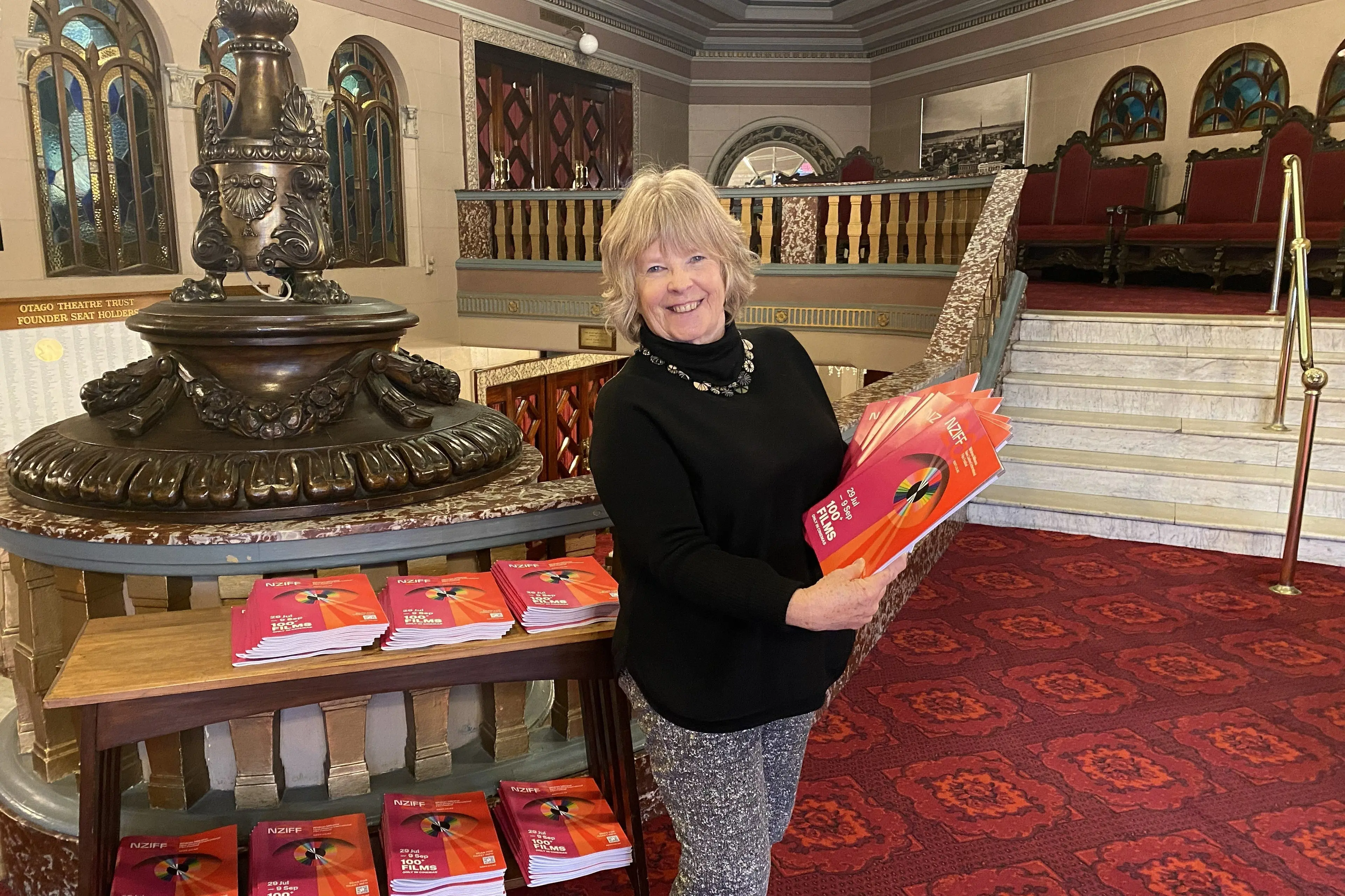Regent Theatre box office administrator Bernie Chatfield holds some of the hundreds of printed Te Wh\\u0101nau Marama New Zealand International Film Festival programmes now available across Dunedin. Photo: Brenda Harwood