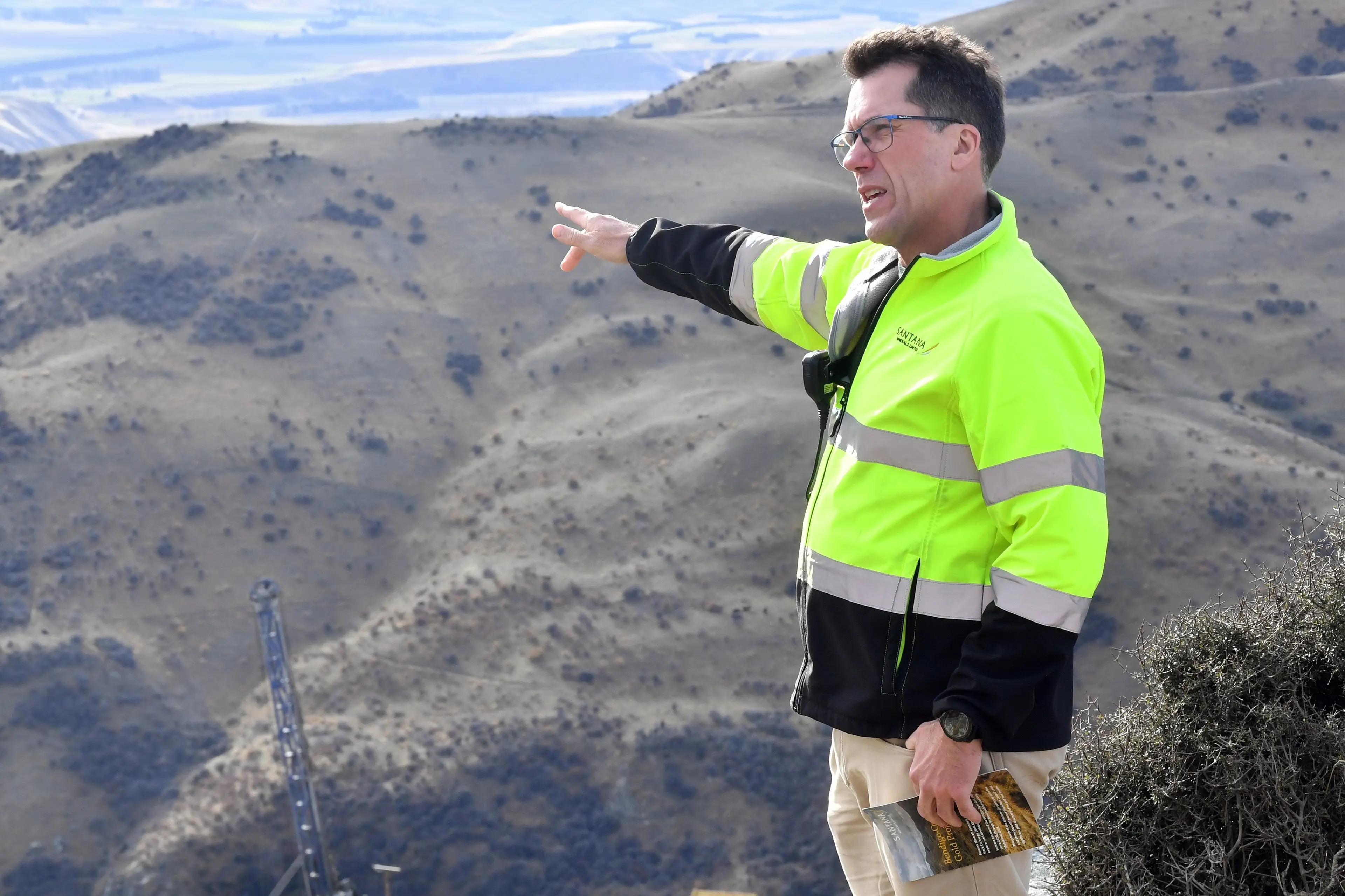 Santana Minerals chief executive Damian Spring points towards the Rise and Shine gold discovery site near Cromwell in 2024. Photo: Stephen Jaquiery