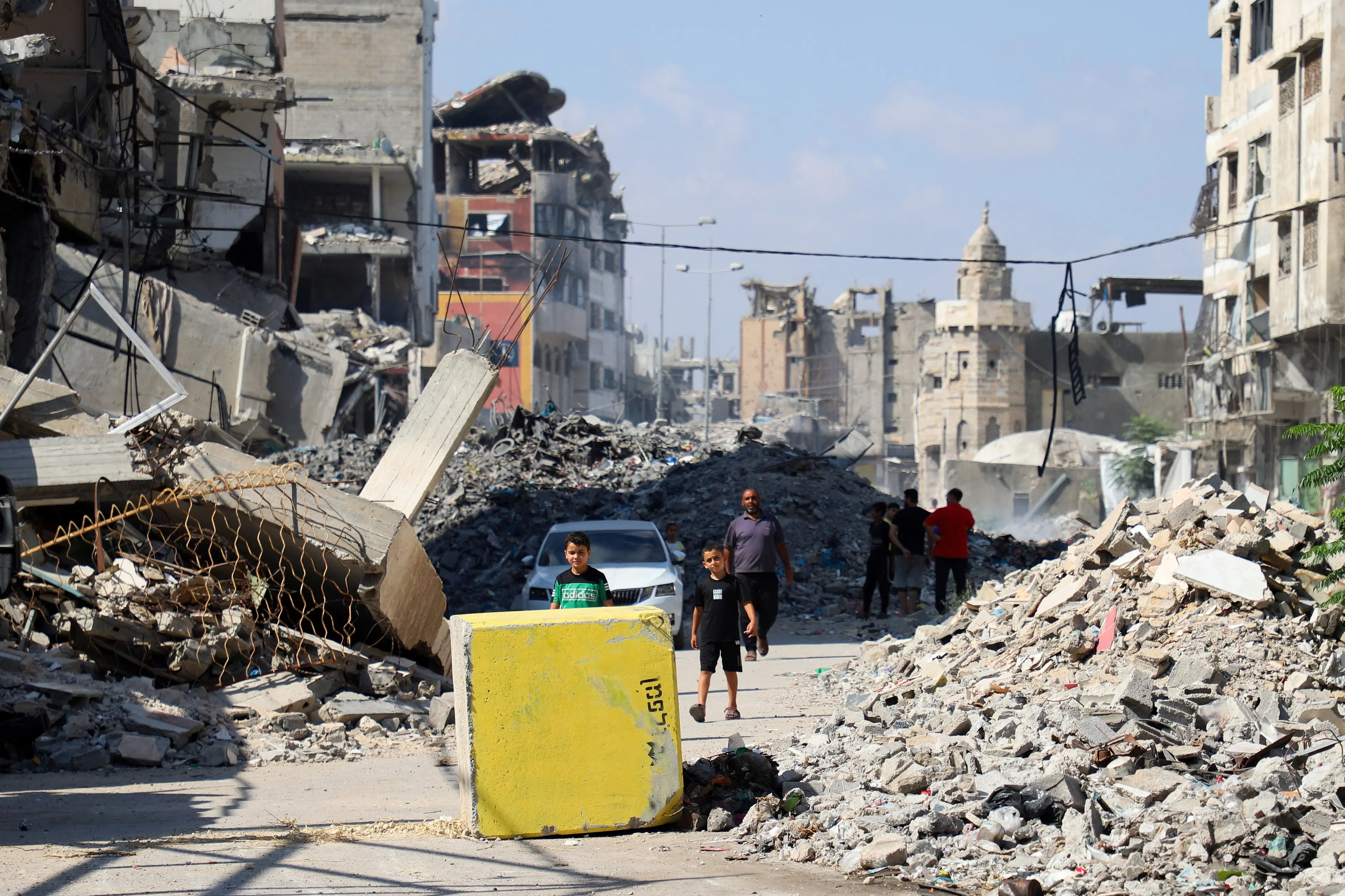 <p>Palestinians look towards a yellow concrete block marking the "yellow zone" under Israeli military control, in Gaza City. Photo: Reuters</p>\\n