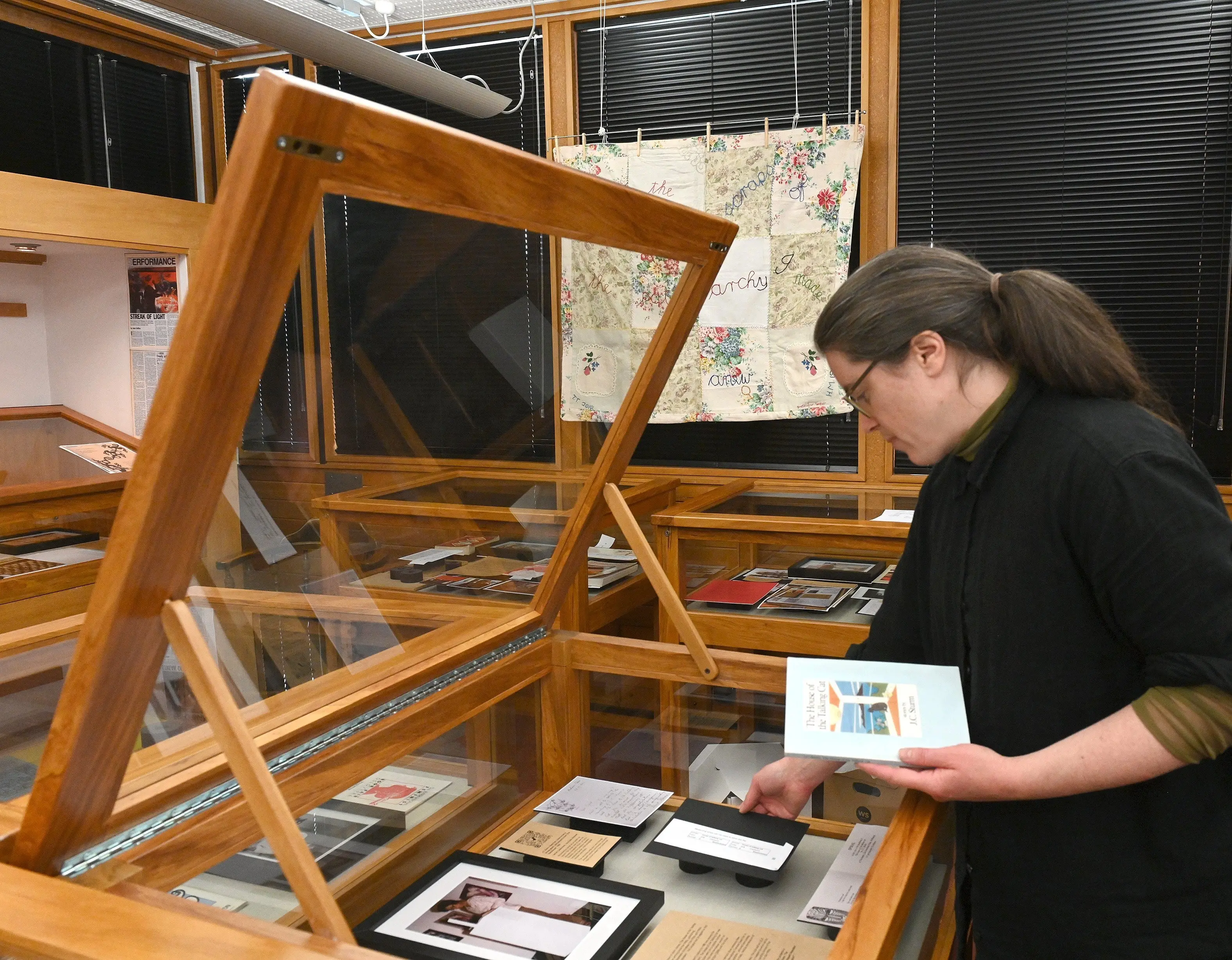 Researcher Joanna Osborne adjusts a display case in the \"Spiral Collectives Exhibition\", Reed Gallery, Dunedin Public Library. Photo: Linda Robertson