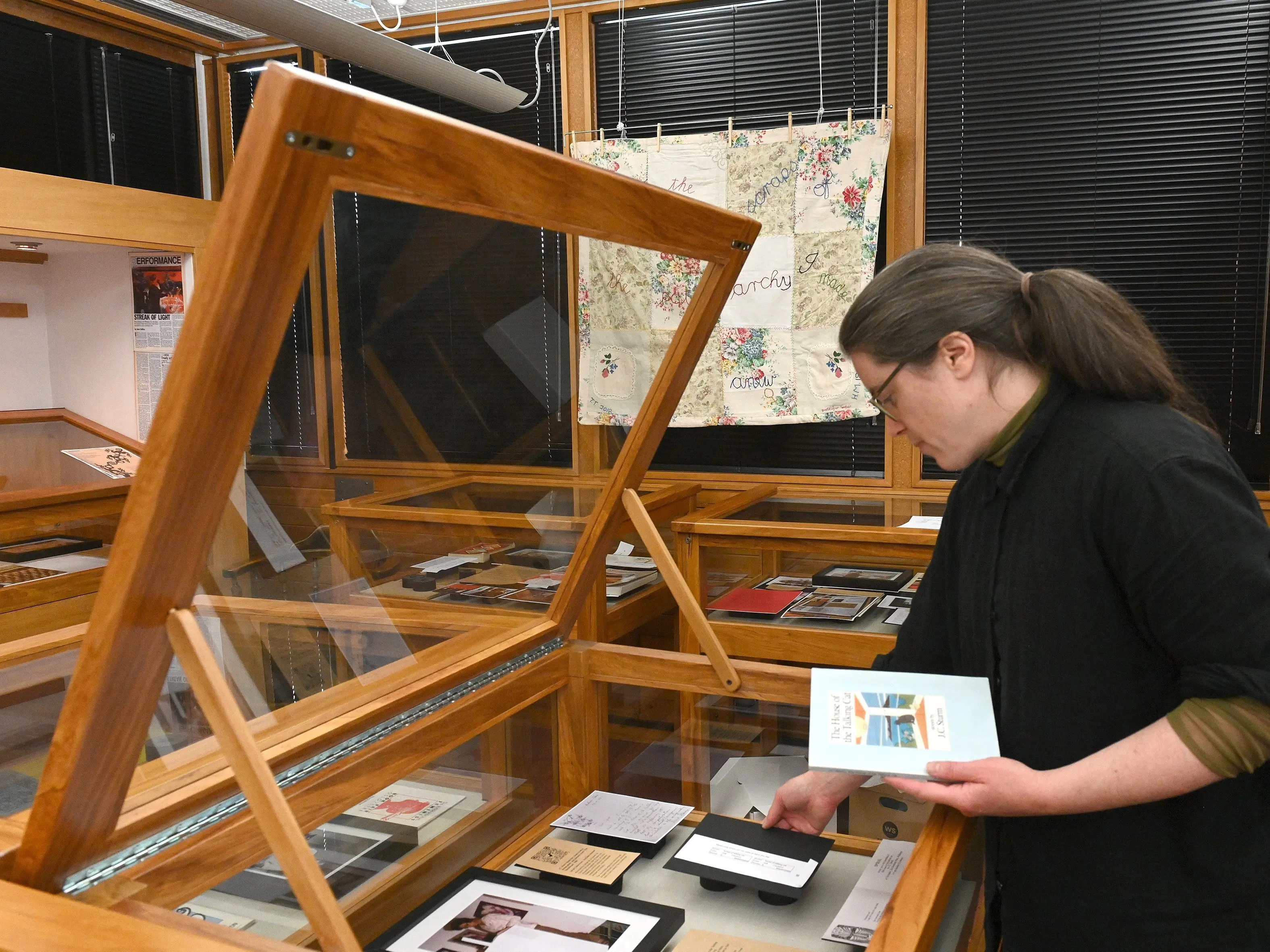 Researcher Joanna Osborne adjusts a display case in the \"Spiral Collectives Exhibition\", Reed Gallery, Dunedin Public Library. Photo: Linda Robertson