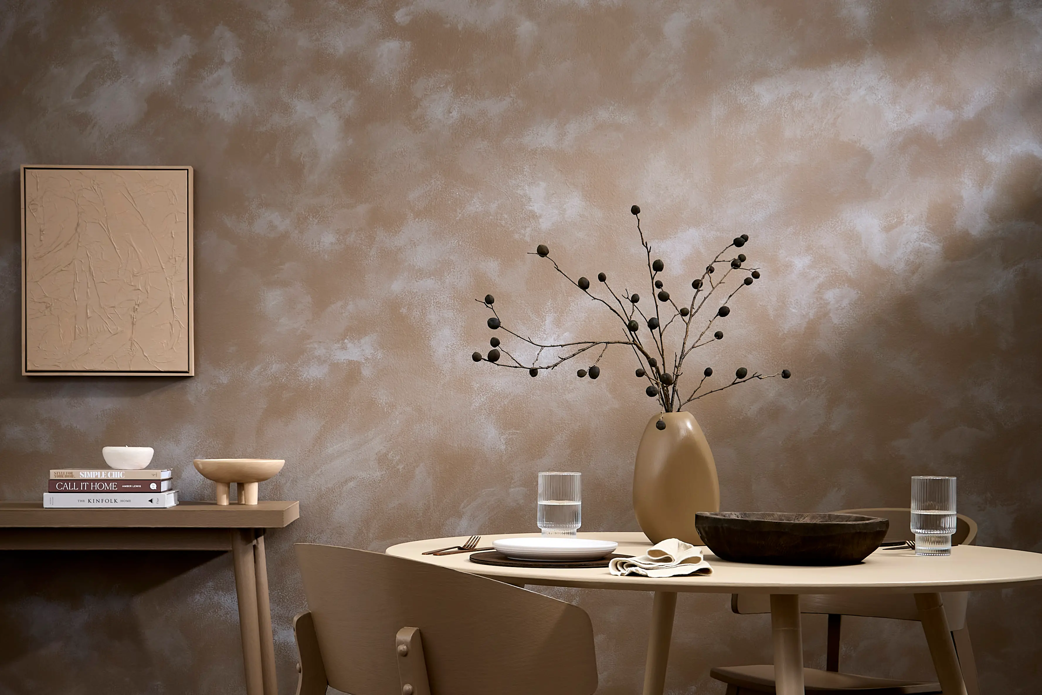 A ragged rear wall gives this dining room the sun-soaked, baked-earth feel of an exotic location. Wall in Resene Tobacco Brown, top coated in Resene FX Paint Effects Medium in Doeskin and Quarter Doeskin, floor washed in Resene Colorwood Grey Wash, table in Doeskin, chairs, vase and console table in Tobacco Brown. (Project Vanessa Nouwens. Image Bryce Carleton)