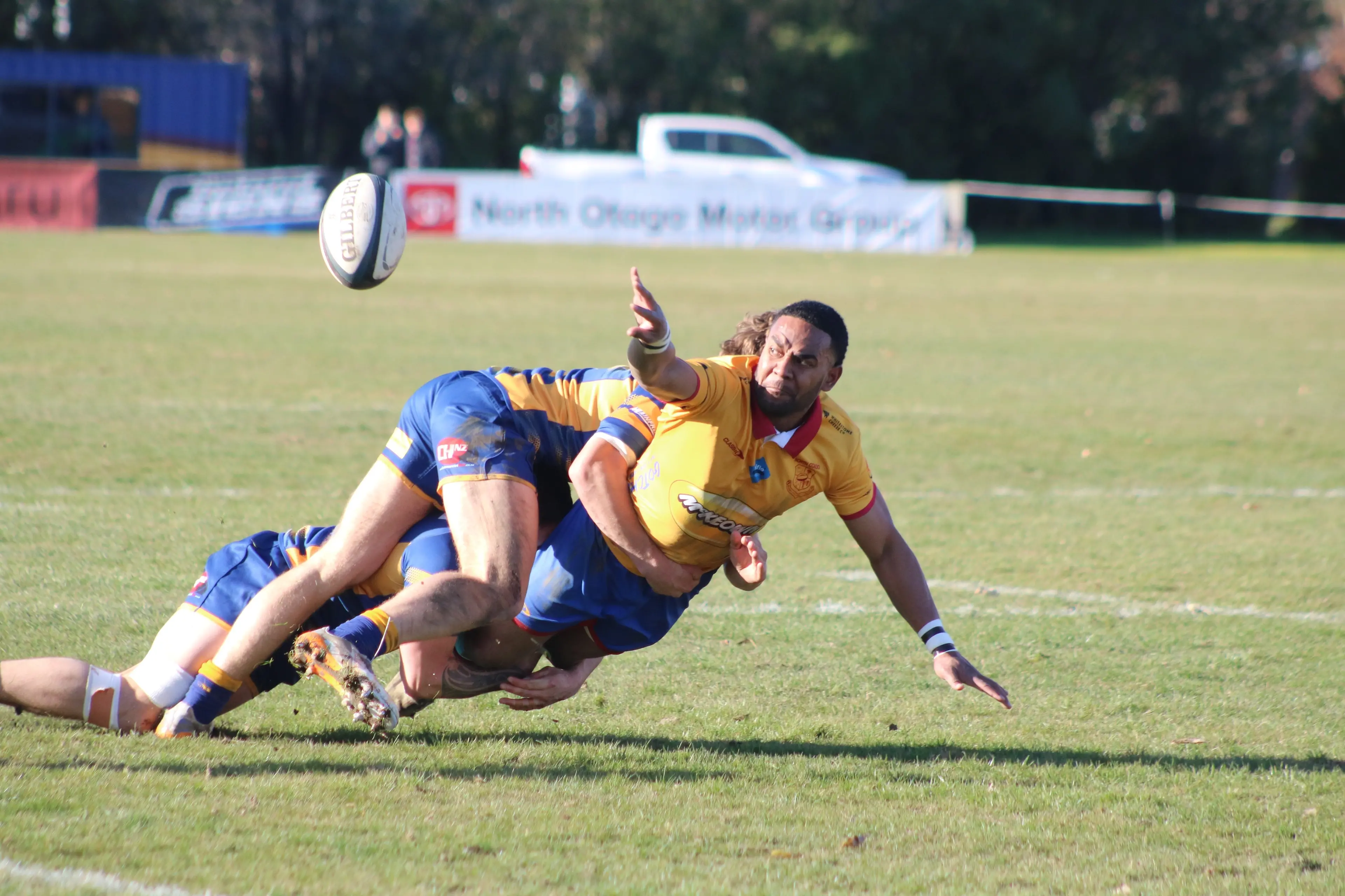 North Otago winger Joji Rinakama\\u00A0offloads the ball through the tackle of Otago Country backs Harry Walker-Leach and Rube Peina during their game in Oamaru. Photo: Kayla Hodge