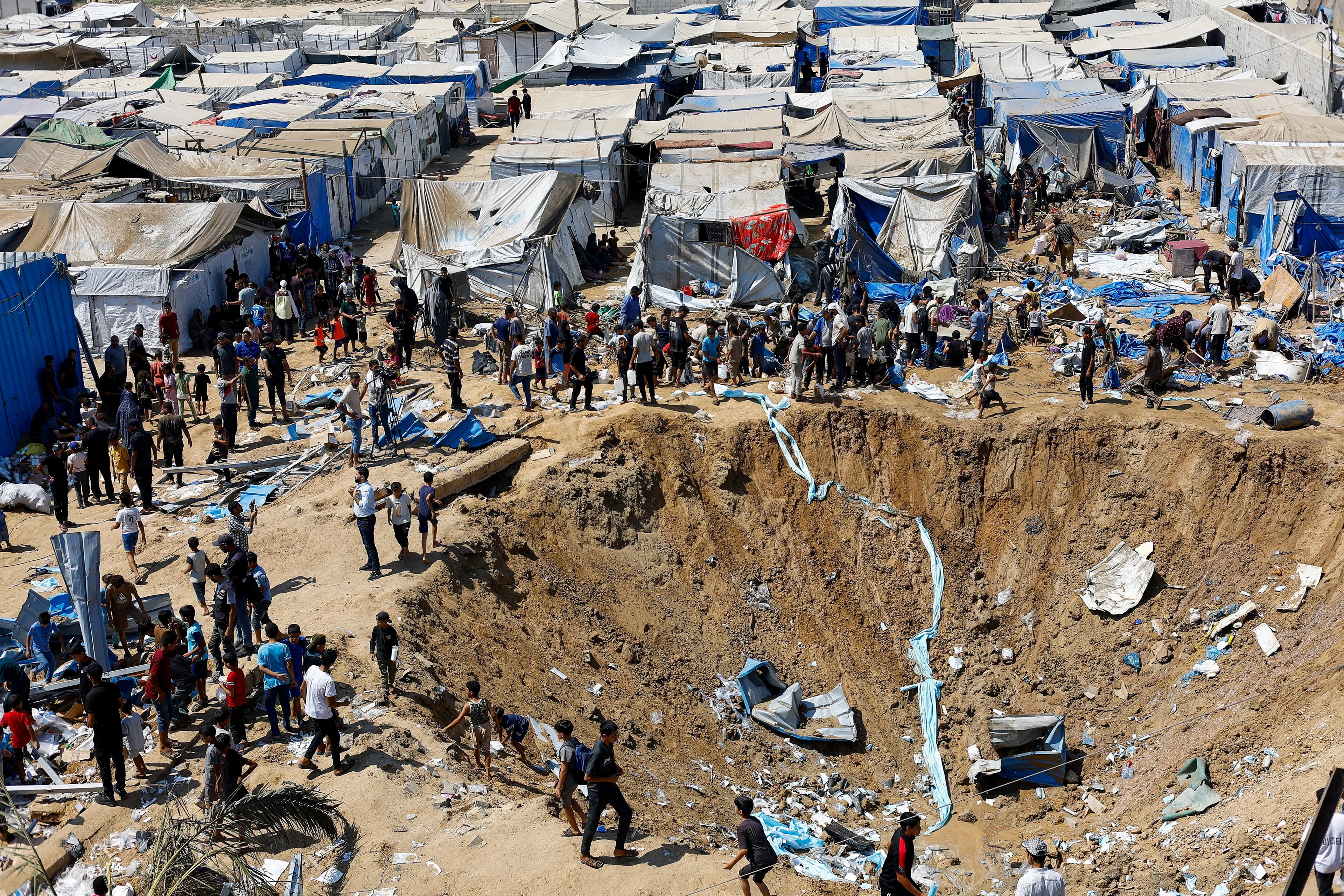 <p>Palestinians inspect the site of an overnight Israeli strike on a medicine warehouse, according to medics, next to tents sheltering displaced Palestinians, in Deir al-Balah, in the central Gaza Strip. Photo: Reuters </p>\\n