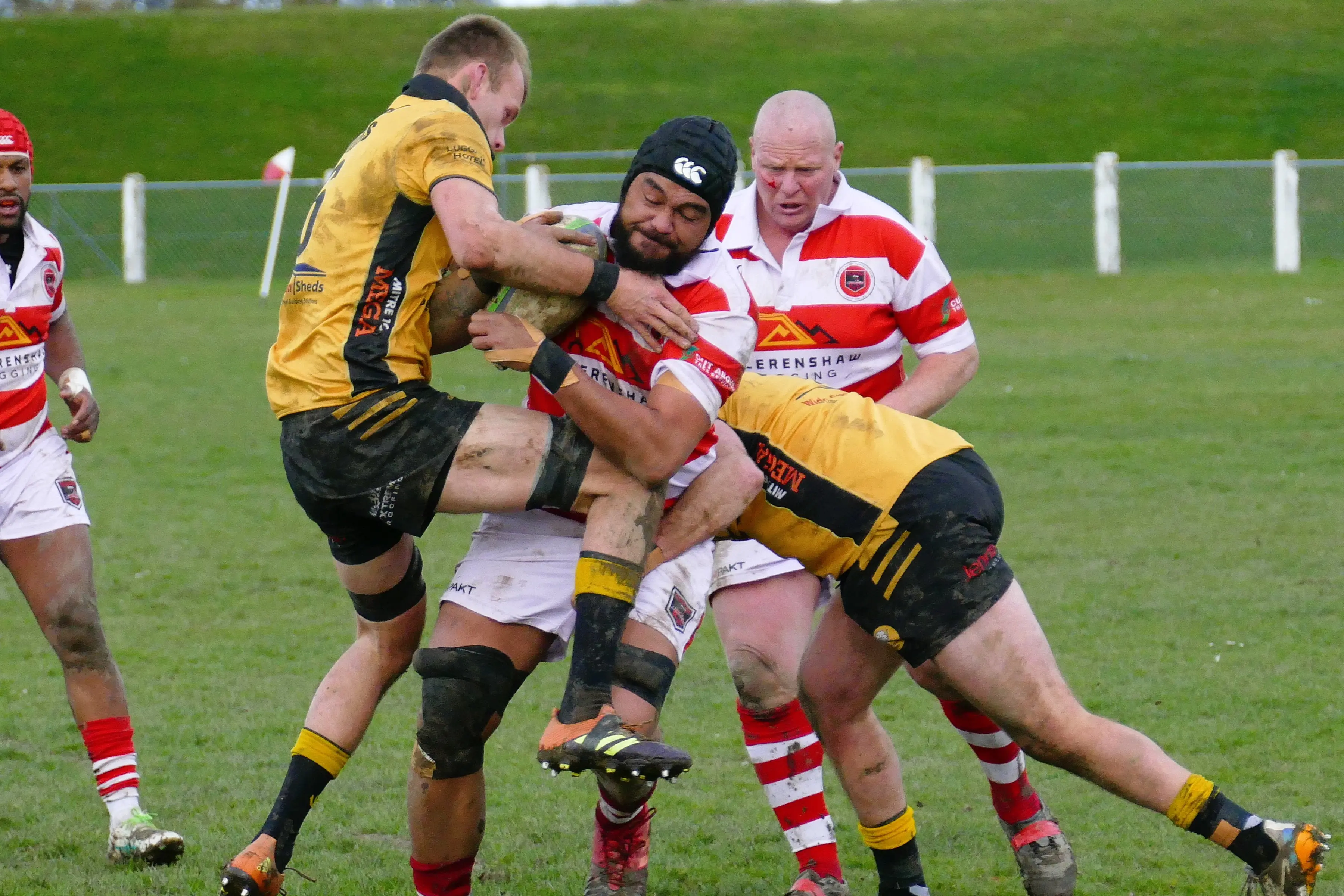 Clutha lock Lene Fetalaiga muscles through an Upper Clutha tackle, watched on by bloodied Clutha prop Phil Keighley, during the teams\\' Countrywide final match at Balclutha Showgrounds on Saturday. Photo: Richard Davison
