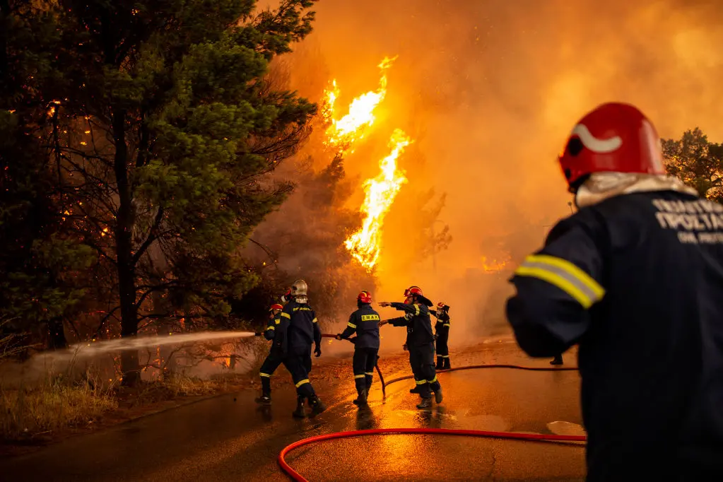 Crews battle a forest fire approaching a gas station in a wooded area north of Athens. Photo: Getty Images