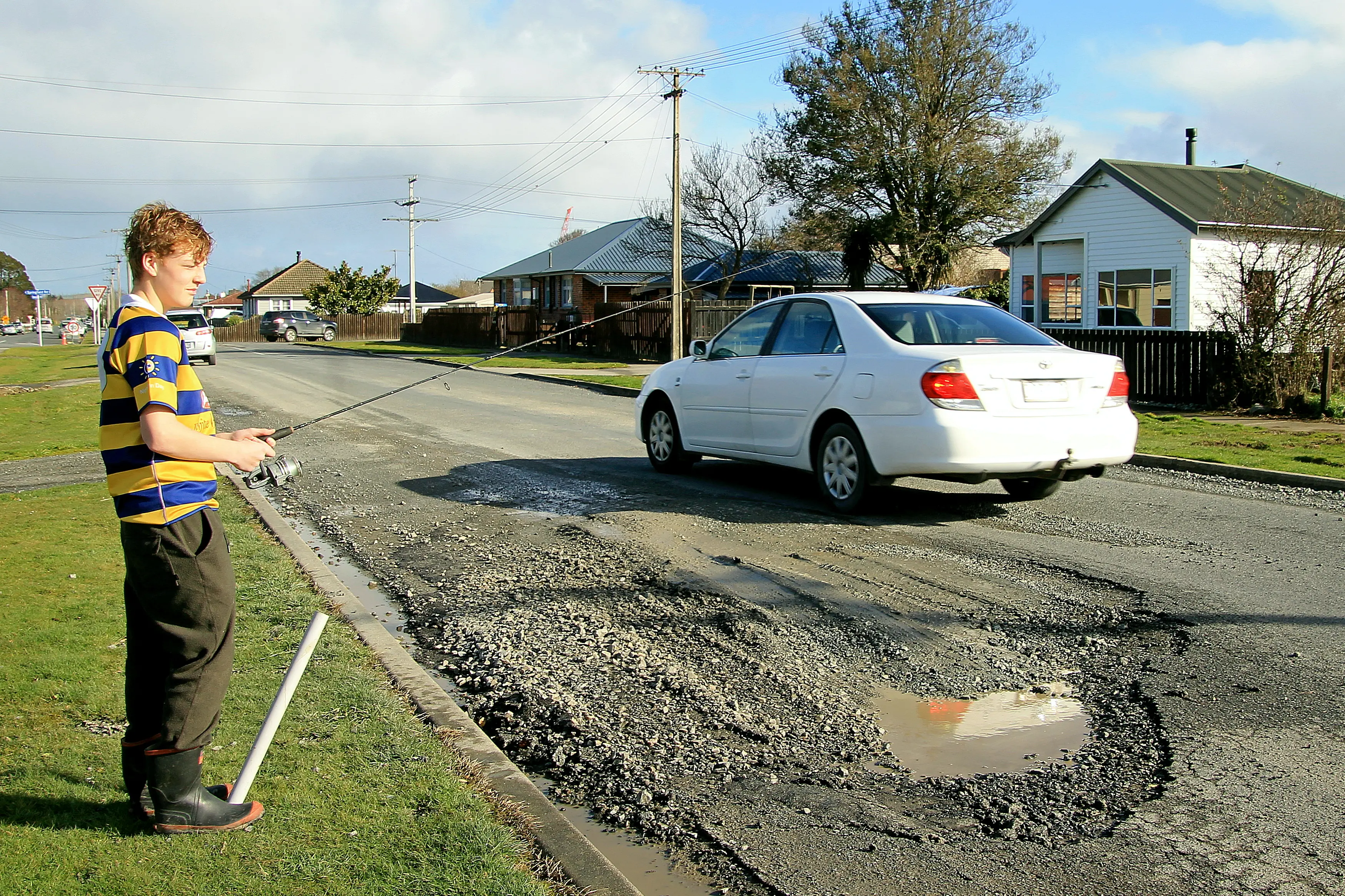 Ben Scott, 14, tries his luck in a pothole on Centennial Ave, Milton. Photo: Nick Brook