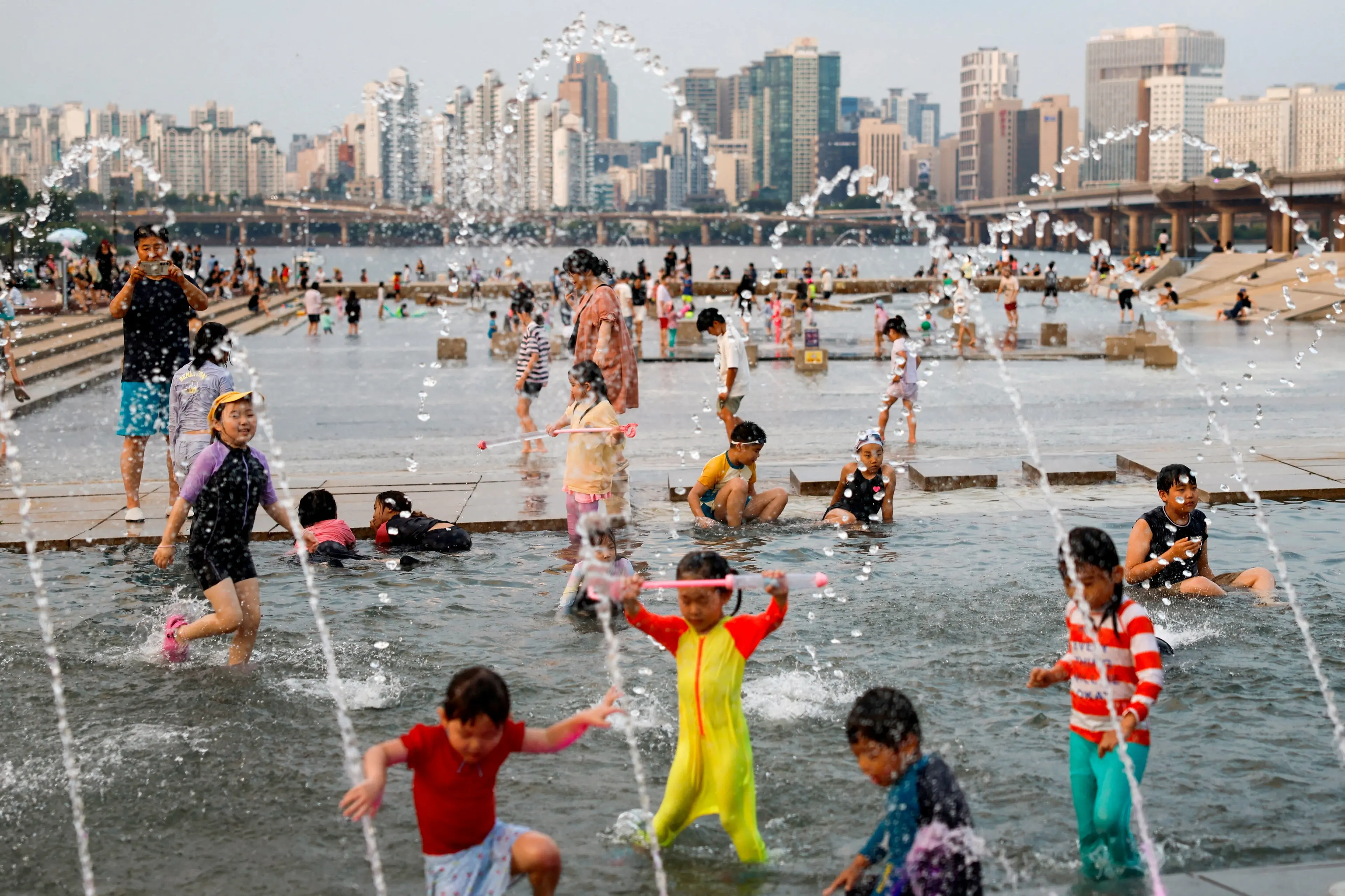 People cool off at a public water plaza along the Han River during a heatwave in Seoul, South Korea. Photo: Reuters