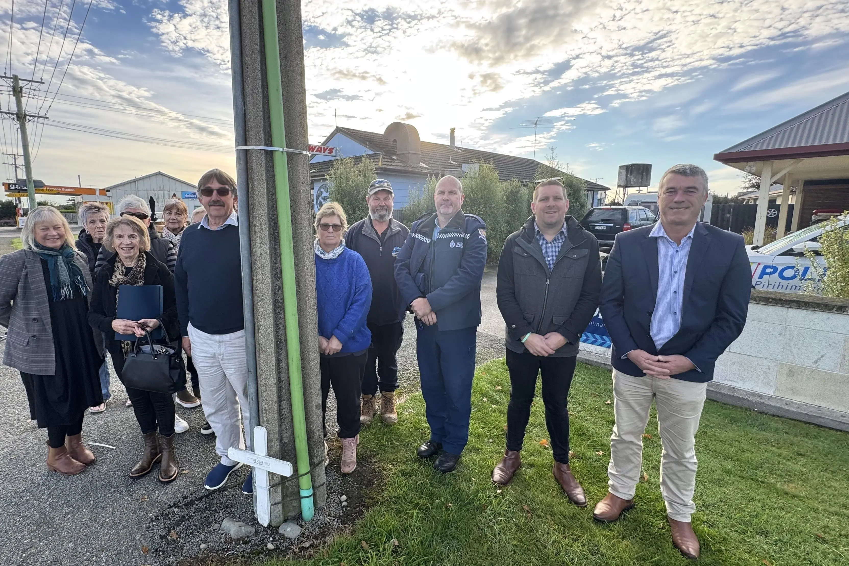 Waihemo Community Board deputy chairman Kerry Stevens (left of utility pole) and Waitaki MP Miles Anderson (far right) are pictured with Hampden residents and police officers who were the driving force behind speed limit changes. Photo: Allied Media Files