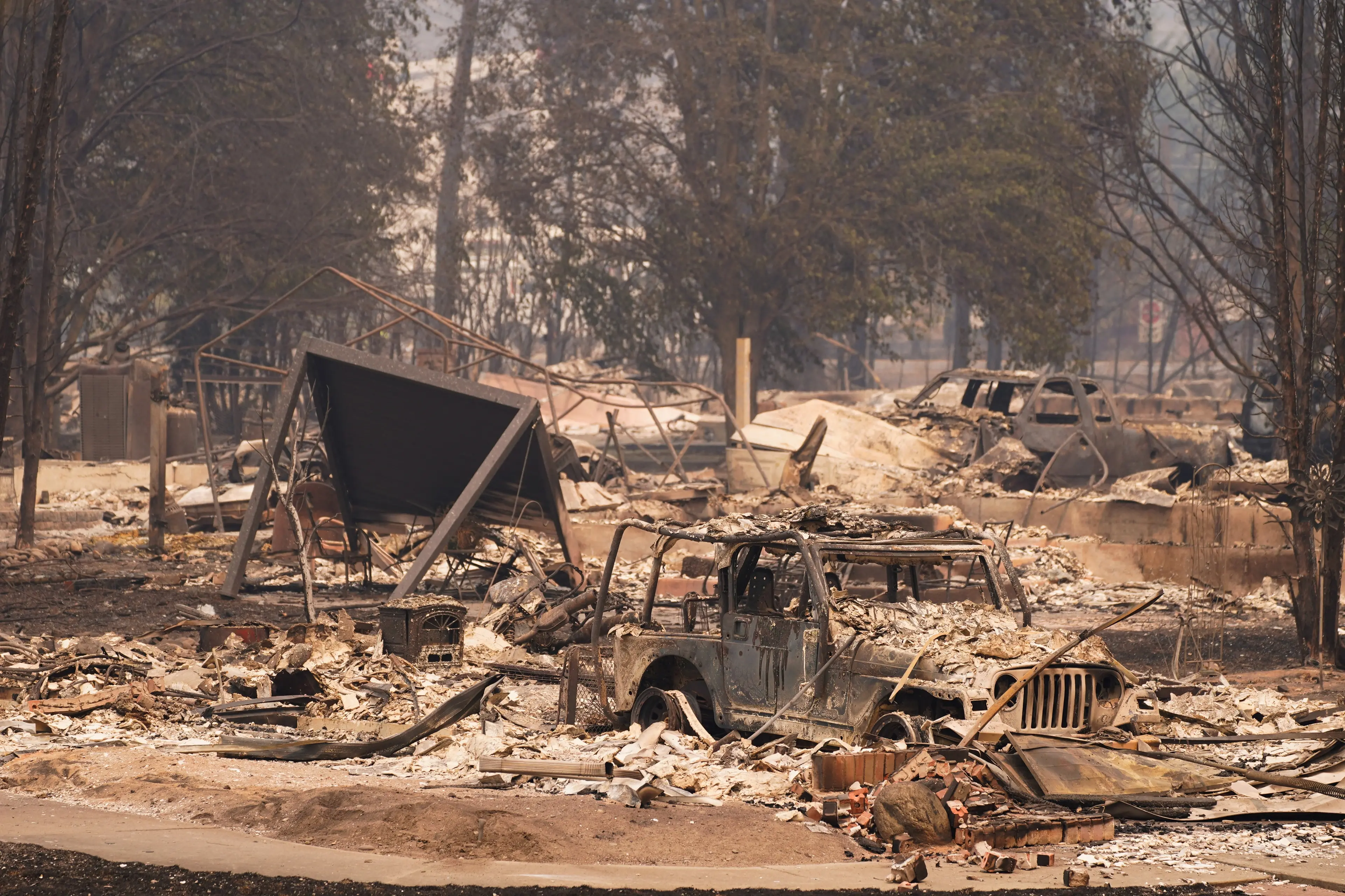 Burned cars sit in a neighbourhood incinerated by the Old Trails Fire in Spokane, Washington. Photo: Reuters
