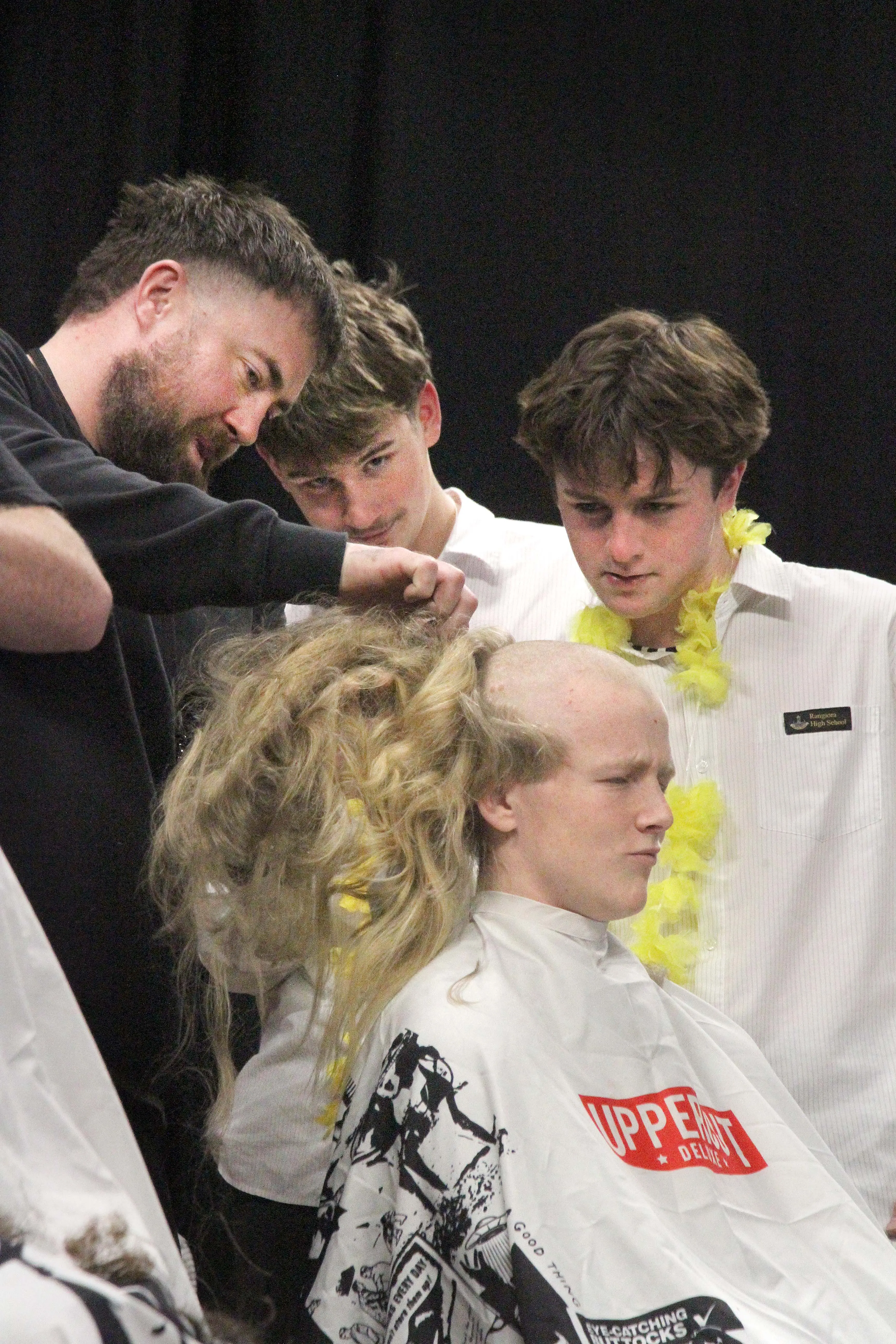 Shaving it off . . . Rangiora High School student Tomo Shaw (17) has his head shaved for charity at the school last week by Tom Weddell, owner of Toms Chop Shop, all while his mates Henry Webb and Mason Woods look on. Photo: John Cosgrove