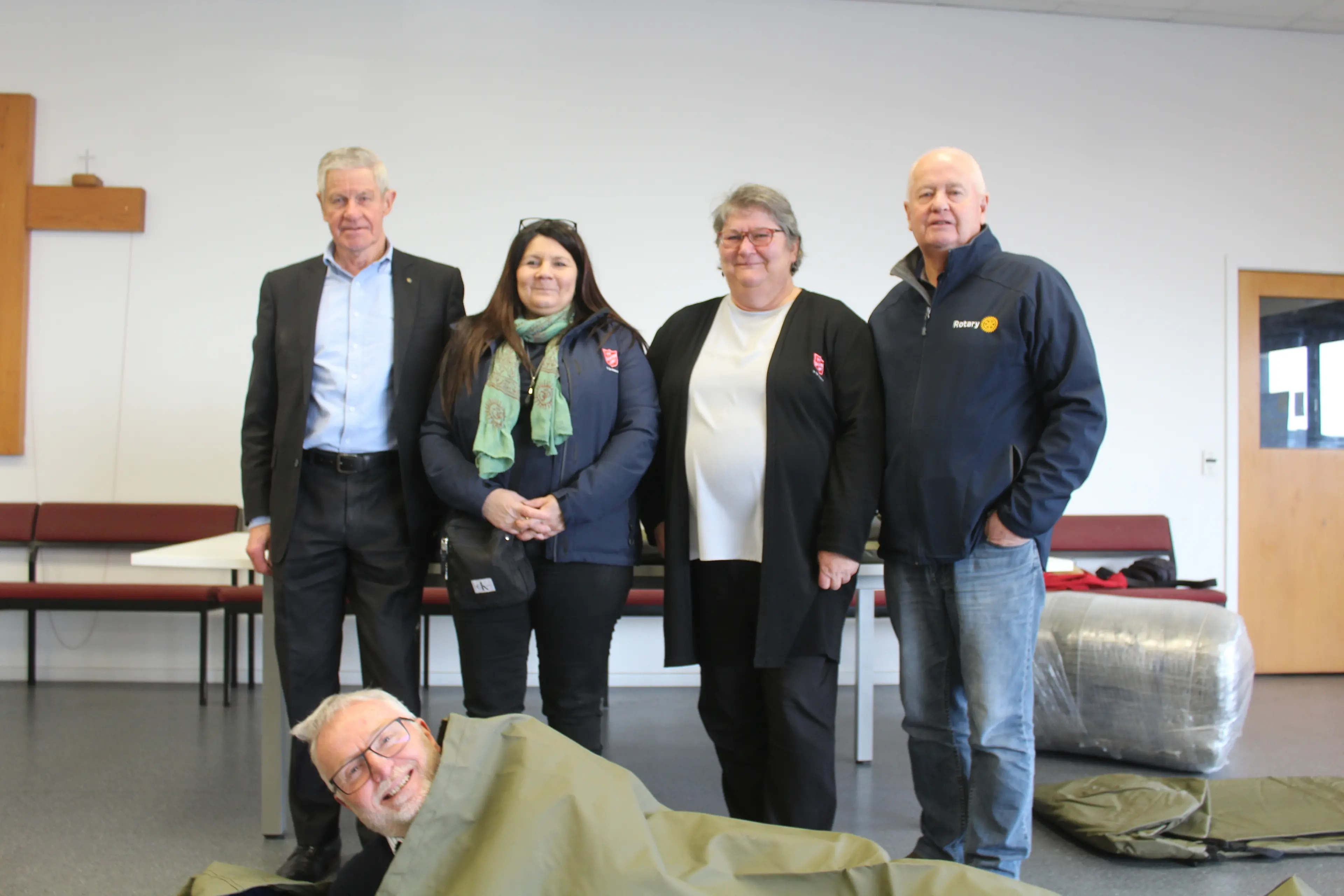 Testing out a shelter bag is past Rotary Club of Invercargill Sunrise president Simon Mapp, while behind him stands (from left) Rotary member Richard Russell, Salvation Army community ministries navigator San Morin, community ministries manager Katherine Sonntag and Rotary Oceania board director Dave McKissock. Photo: Tayler Mutton