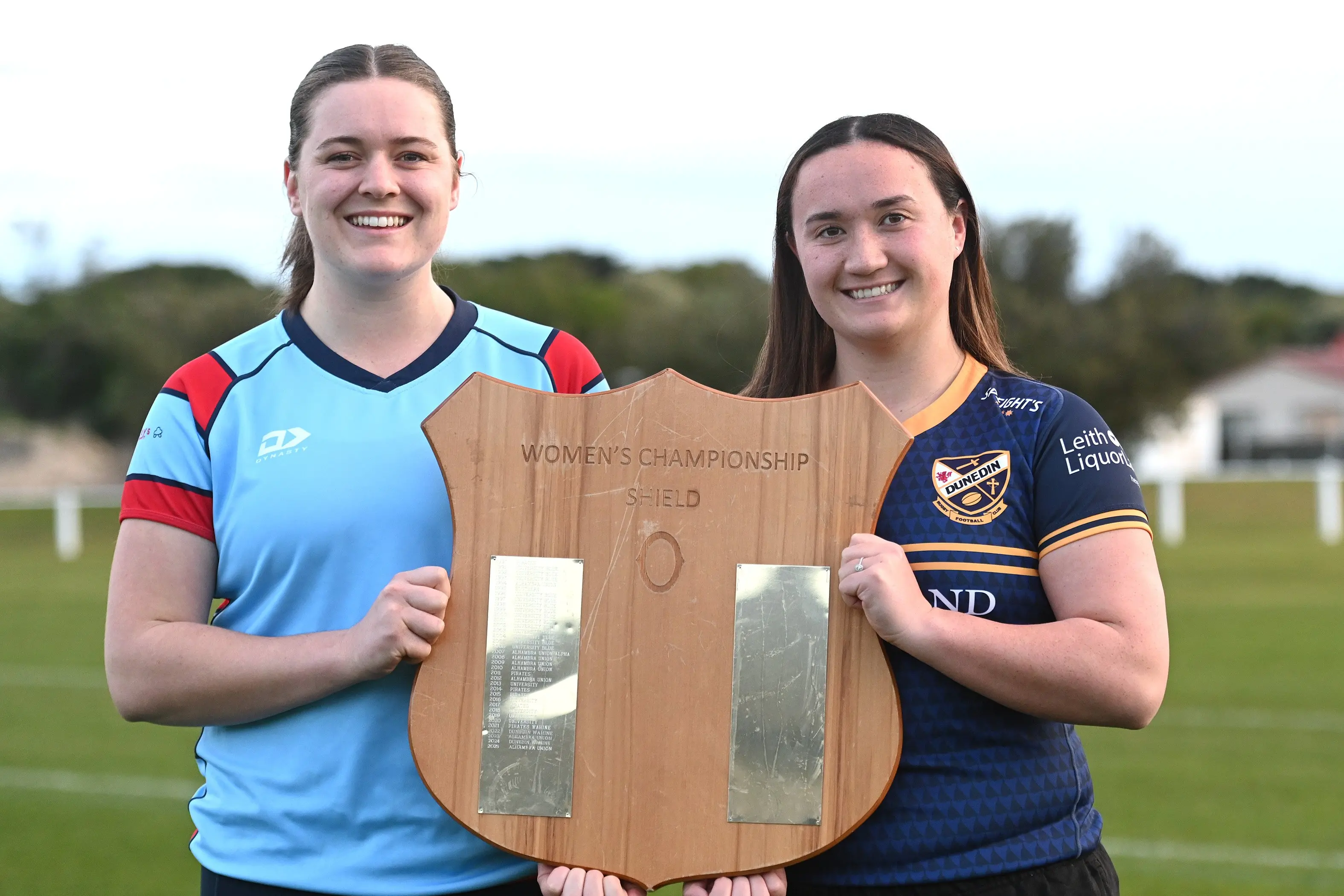 Ella Gomez of Big River Country (left) and Oceana Campbell of Dunedin Sharks Ururoa with the Women\\'s Rugby Shield both teams will compete for on Saturday. Photo: Linda Robertson