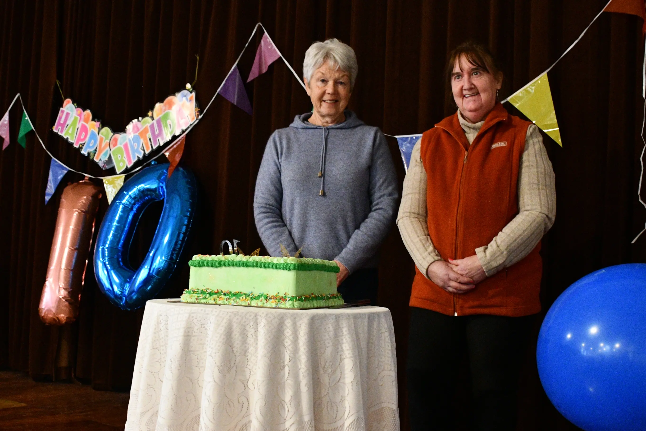 Gore Hokonui Community Market founder Margaret Cochrane (left) and committee member Tarnya Johnson acknowledge ten years of the charitable monthly event with cake. Photo: Gemma Sinclair