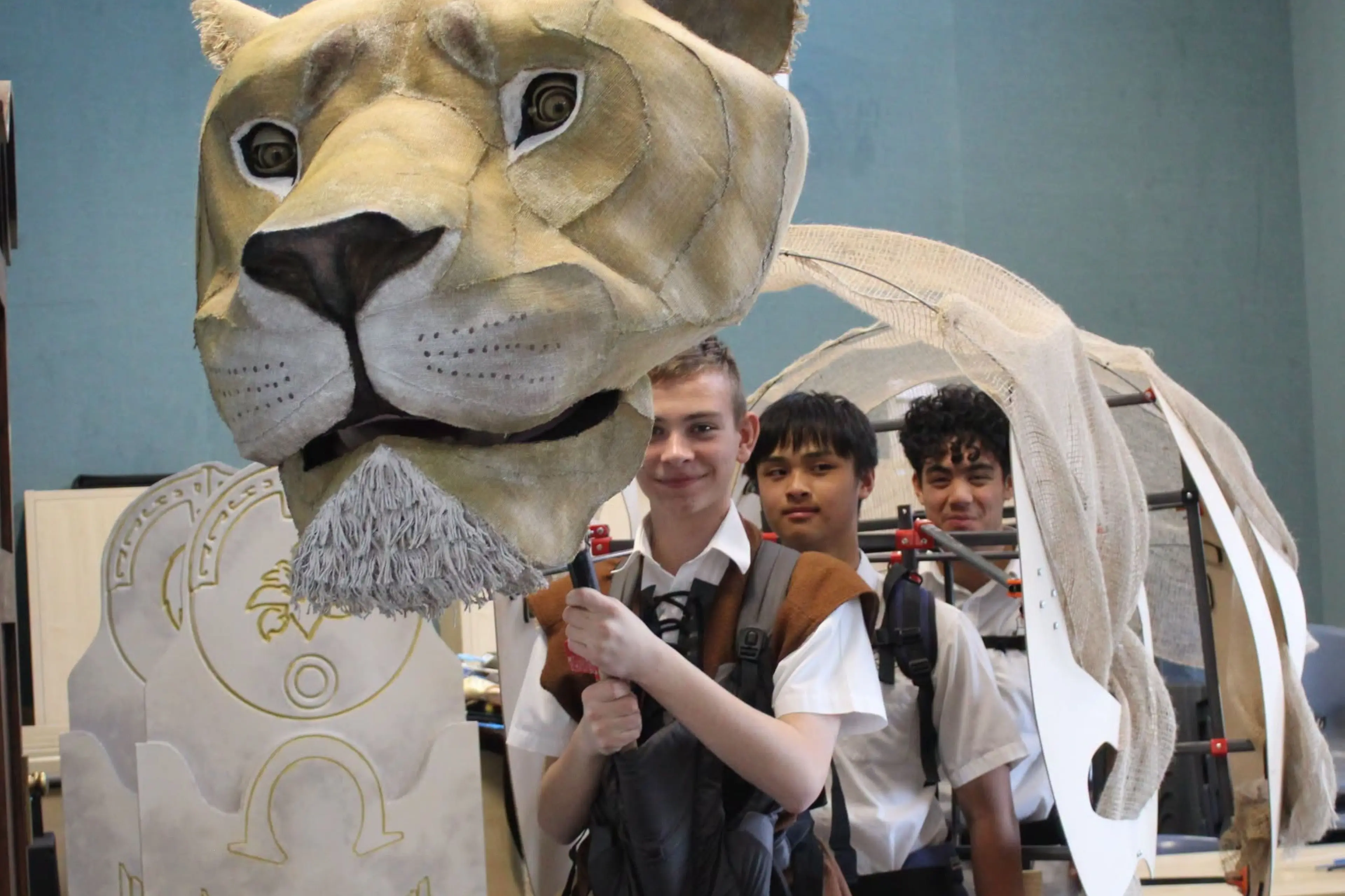Puppeteers mastering the art of bringing Aslan the lion to life are, from left, Sasha Ivashchencko, Max Shen and Seth Ong. Photo: Supplied