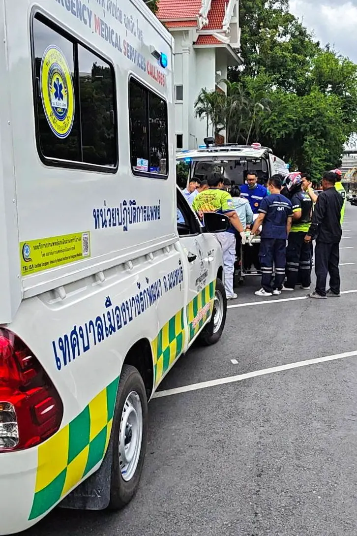 A worker receives medical help after being shot at a government office in Nonthaburi, on the outskirts of Bangkok. Photo: Talingchan520/Handout via Reuters