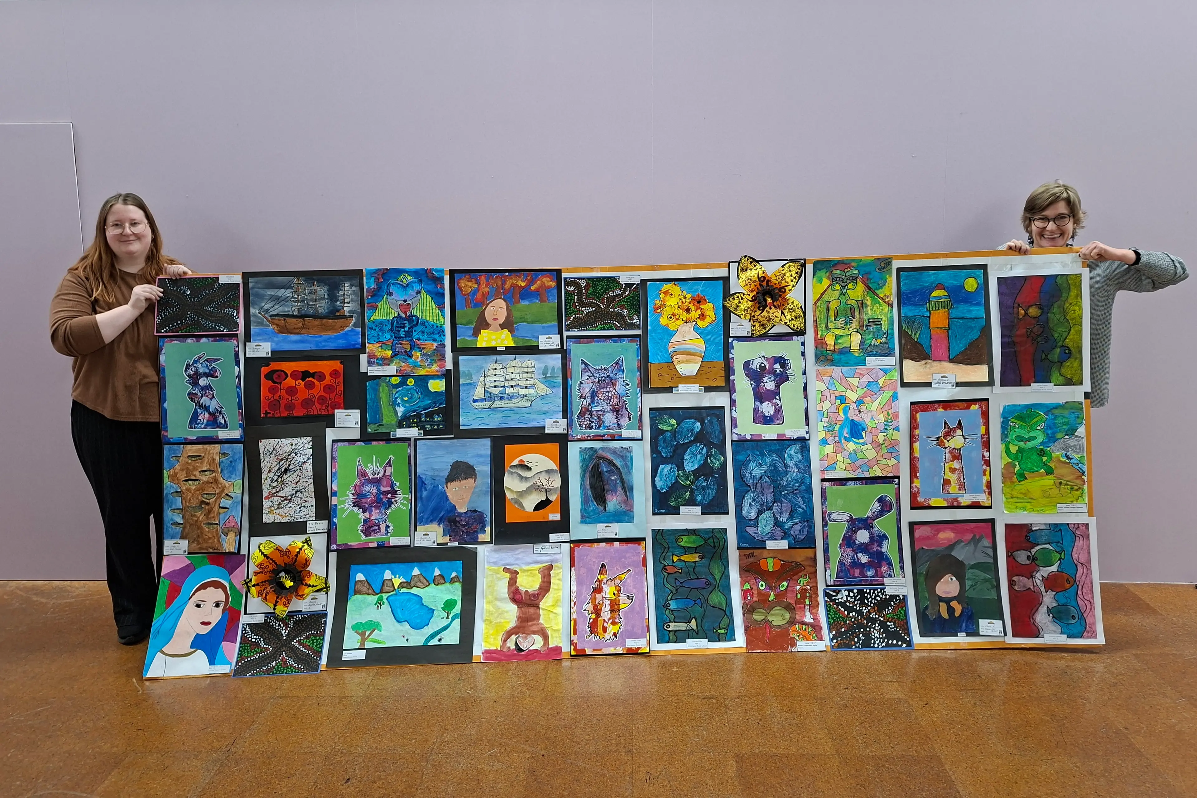 Aigantighe Art Gallery assistant Anna Mathison (left) and collections curator Petrena Fishburn hold a colourful collage of Artarama entries created by year 4-6 students. Photo: Cara Fitzgerald