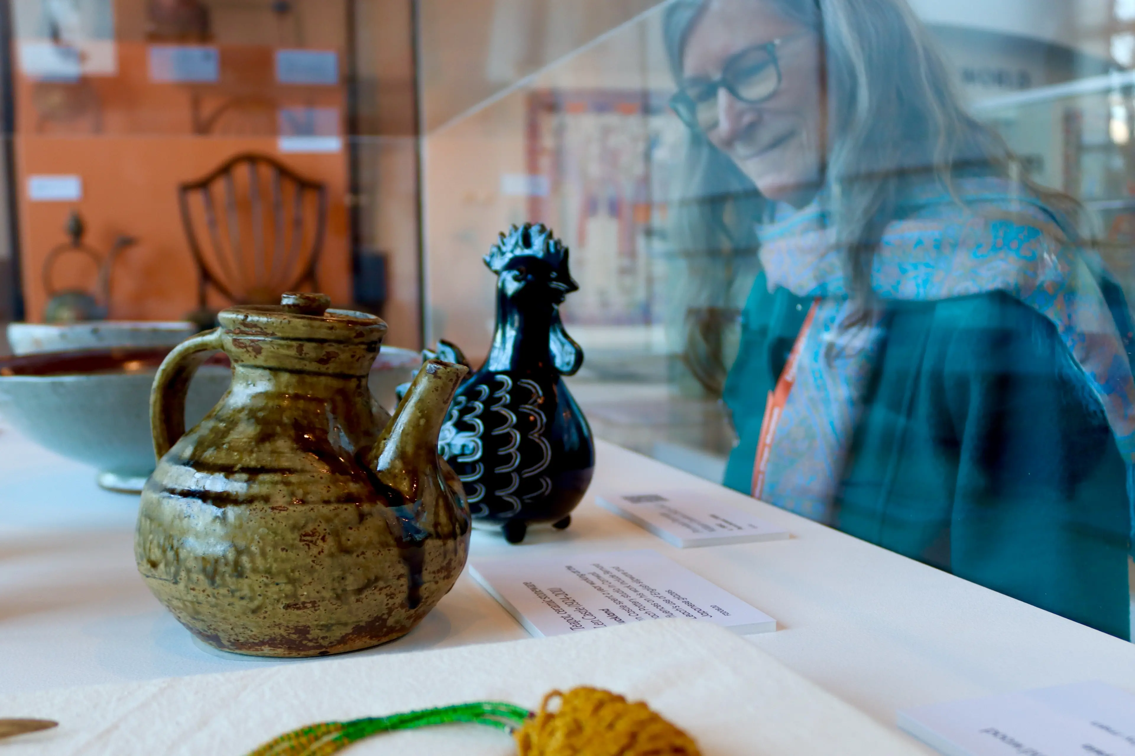 Emeritus professor Nancy Longnecker inspects a ceramic teapot by Len Castle and a porcelain partridge by William Gordon. Photo: Sam Henderson