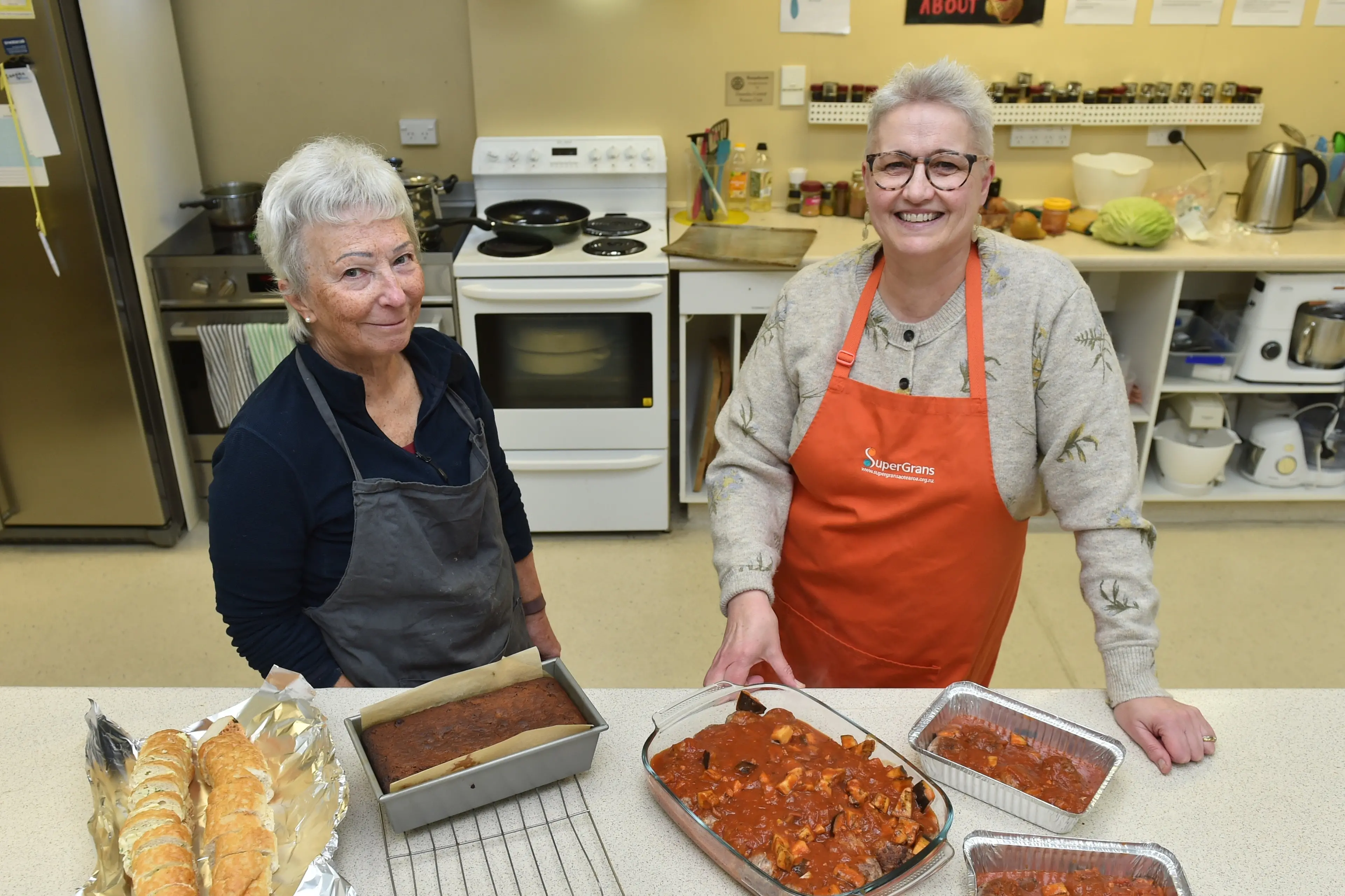 SuperGrans member Denise Blake (left) and manager Philippa Wright get to work making meals for charity at their South City Mall location recently. Photo: Gregor Richardson
