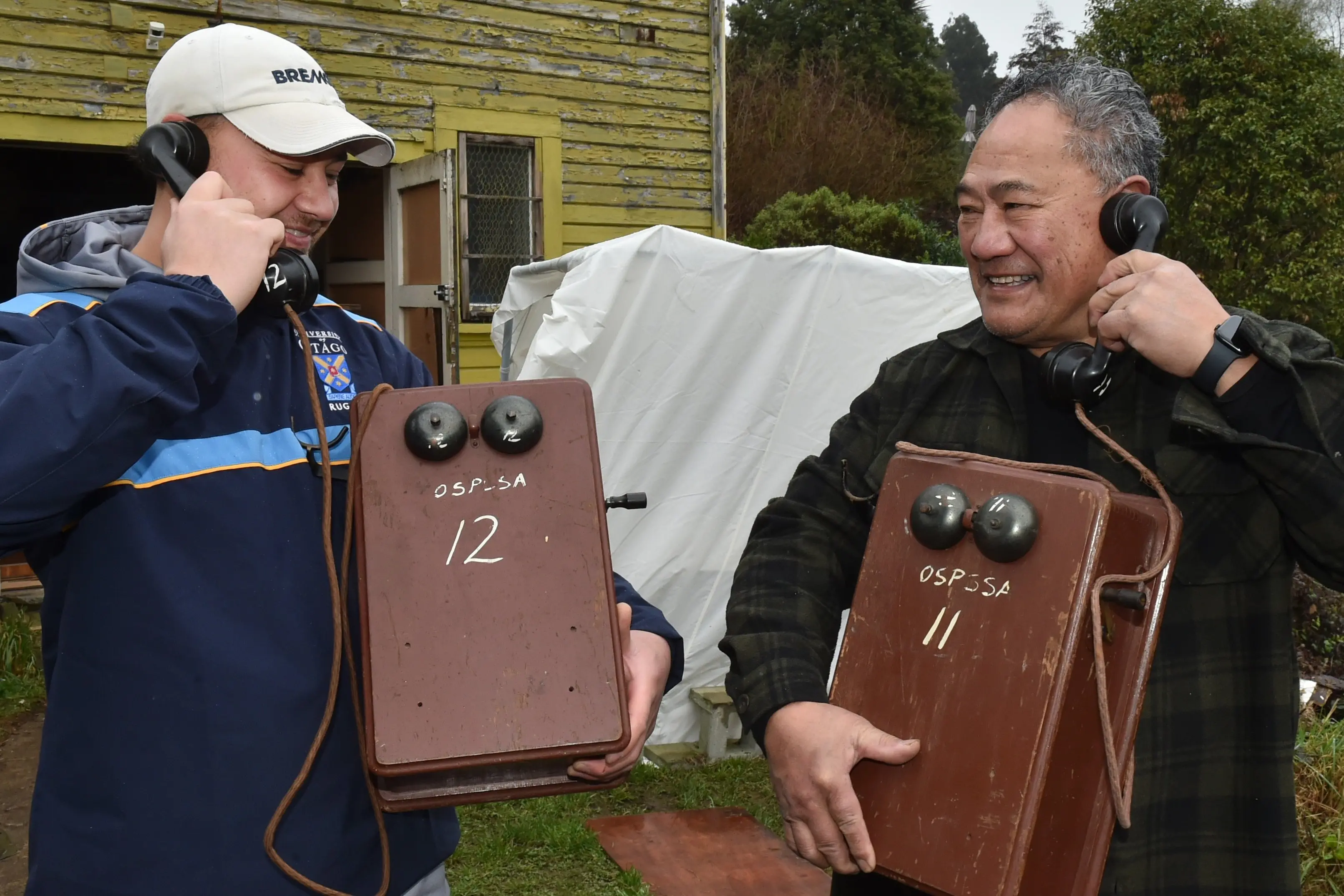 Hagan Leiataua and father Henry Leiataua hold a couple of antique party-line telephones they bought at Dunedin radio and television enthusiast Kevin Weatherall\\u2019s\\u00A0 vintage valve radio and electronic clearance sale  in Caversham  on Saturday. Photo: Gregor Richardson