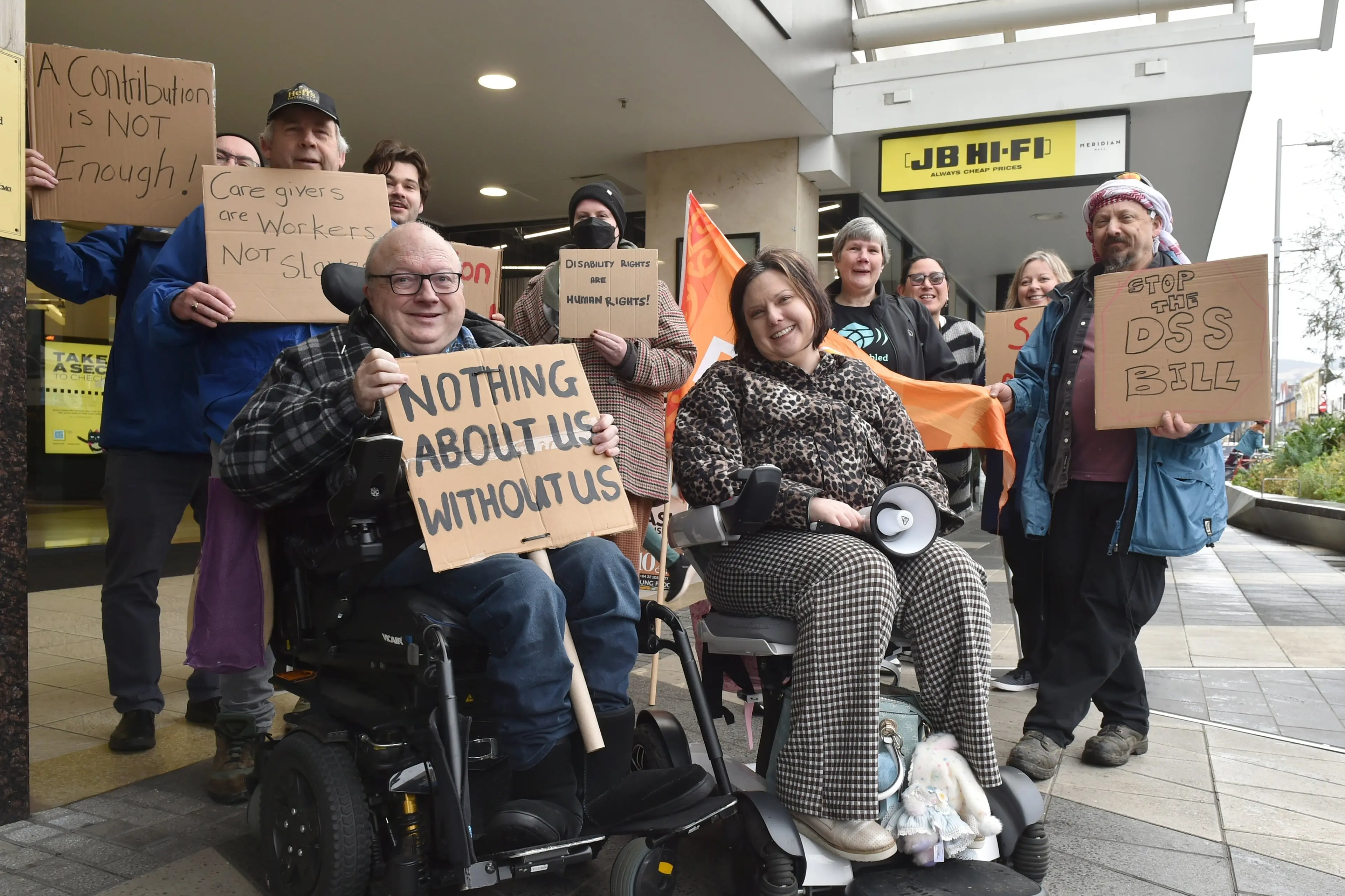 Chris Ford (front, left) and Amy Taylor (front, right) lead a day of action, in George St, airing concerns about the Disability Support Services Bill that will affect people with disabilities and their carers. Photo: Gregor Richardson