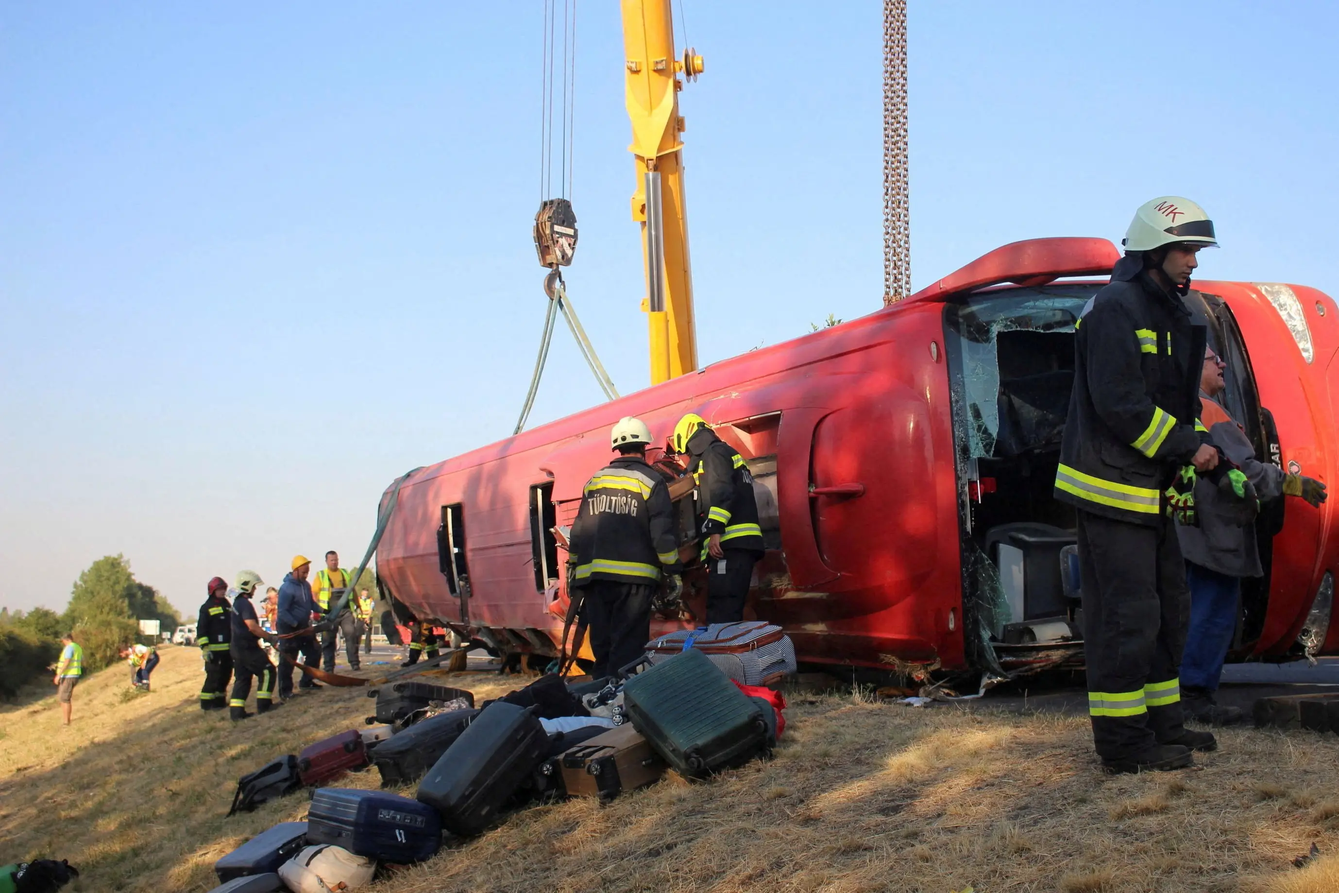 Firefighters work at the scene of a deadly accident, where a Polish bus carrying tourists veered off the motorway and overturned, near Mezokeresztes, Hungary. Photo: Reuters