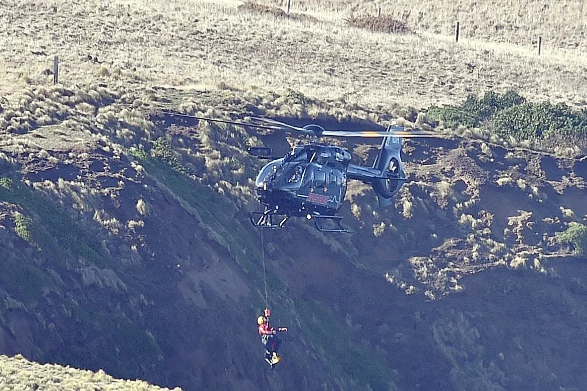 A Helicopters Otago helicopter begins a winch of a surfer who got into trouble at Smaills Beach on Sunday. Photo: Gregor Richardson