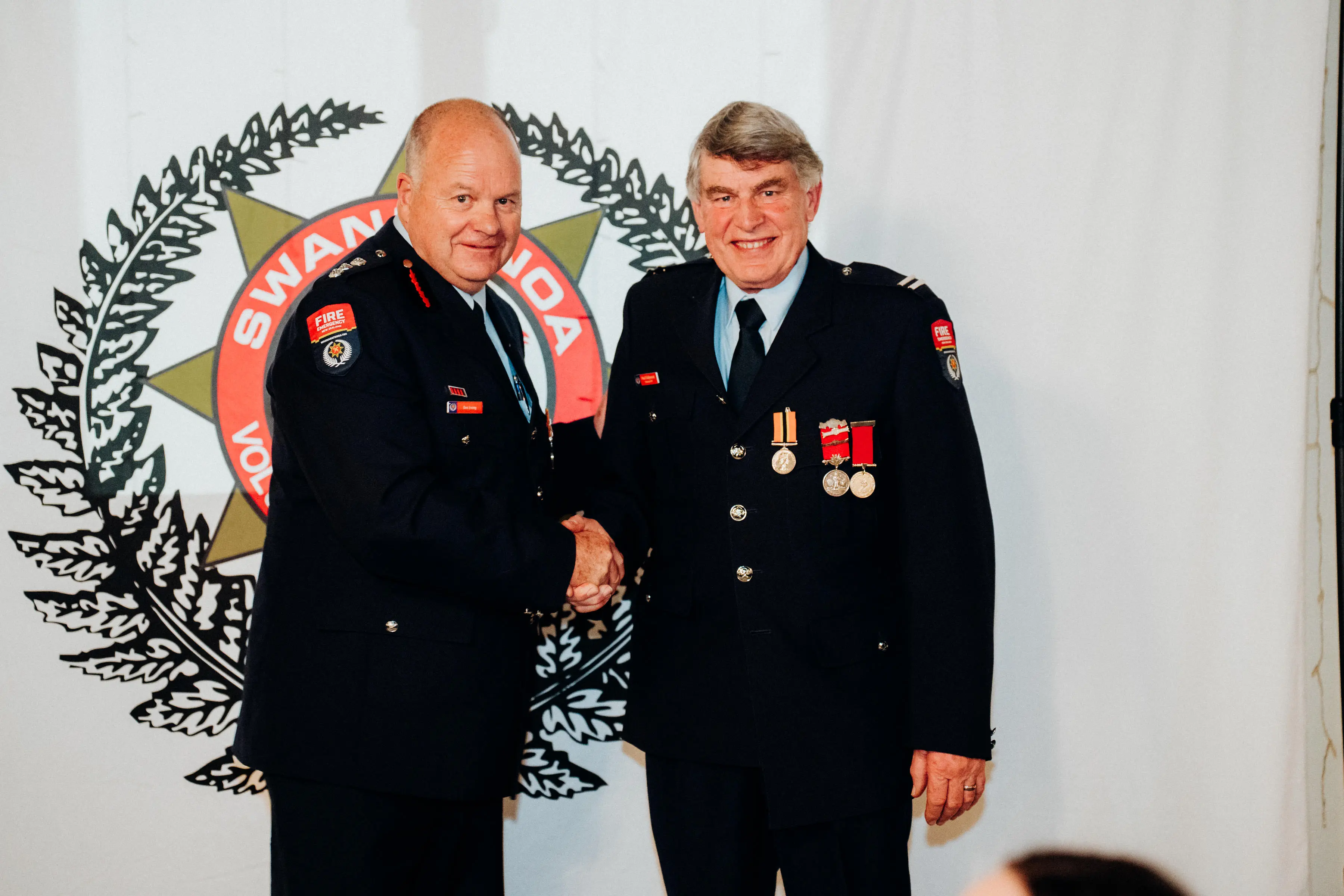 Long service medal . . . The FENZ Assistant District Commissioner Des Irving (left) presents Senior Firefighter Paul Fiddymont of Swannanoa with his King\\u2019s Long Service and Good Conduct medal. Photo: Niall Featherstone Photography