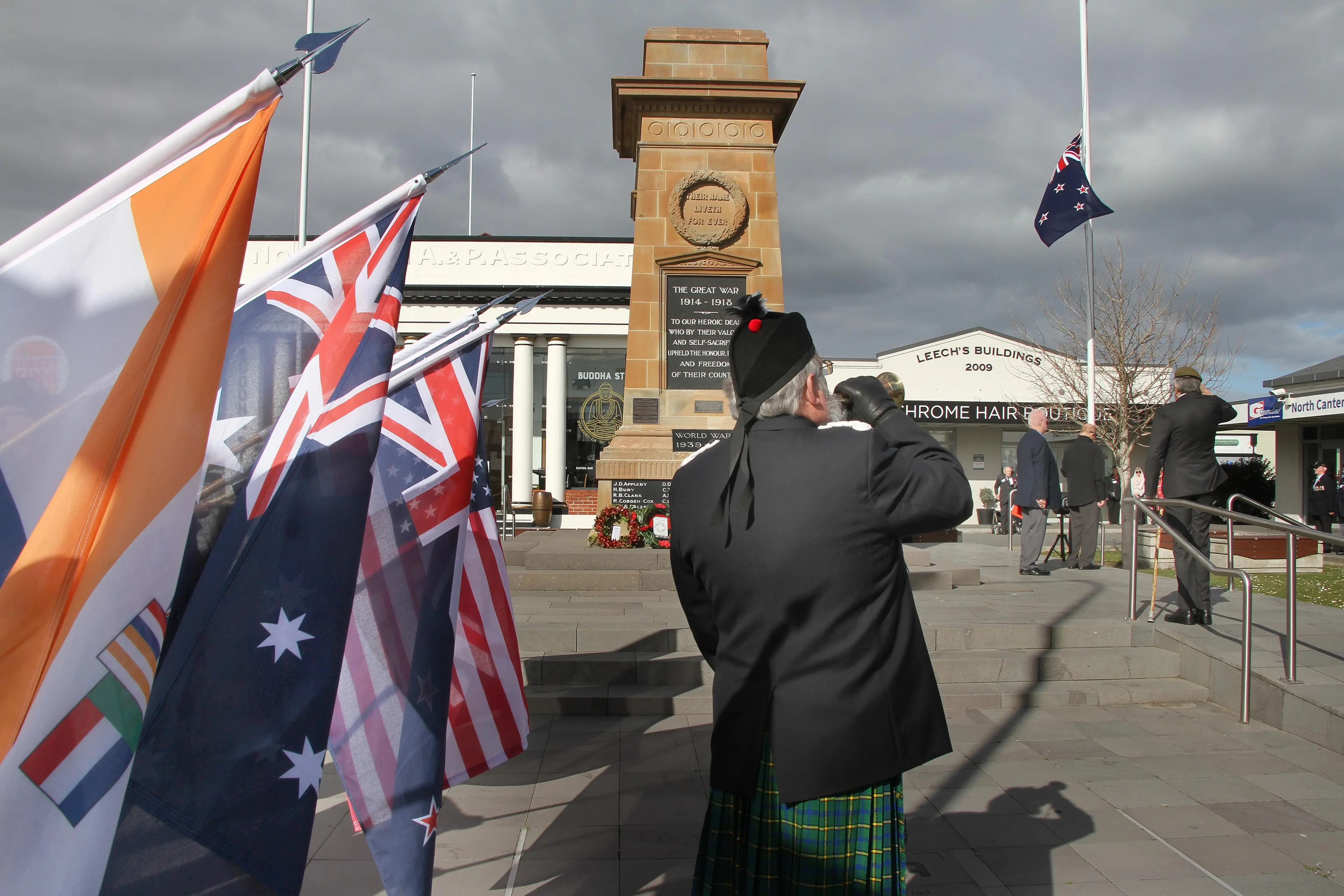 In Memory . . .Flags of seven nations are lowered as Rangiora RSA Padre Bill Peck plays the last post and reveille at the Rangiora Cenotaph during the Rangiora RSA Veterans Day commemoration service attended by 140 vets on Tuesday. Photo: John Cosgrove