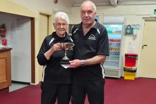 Neisha Hogg and Alan Reid with the trophy for winning the South Canterbury Open Championship pairs. Photo: Supplied