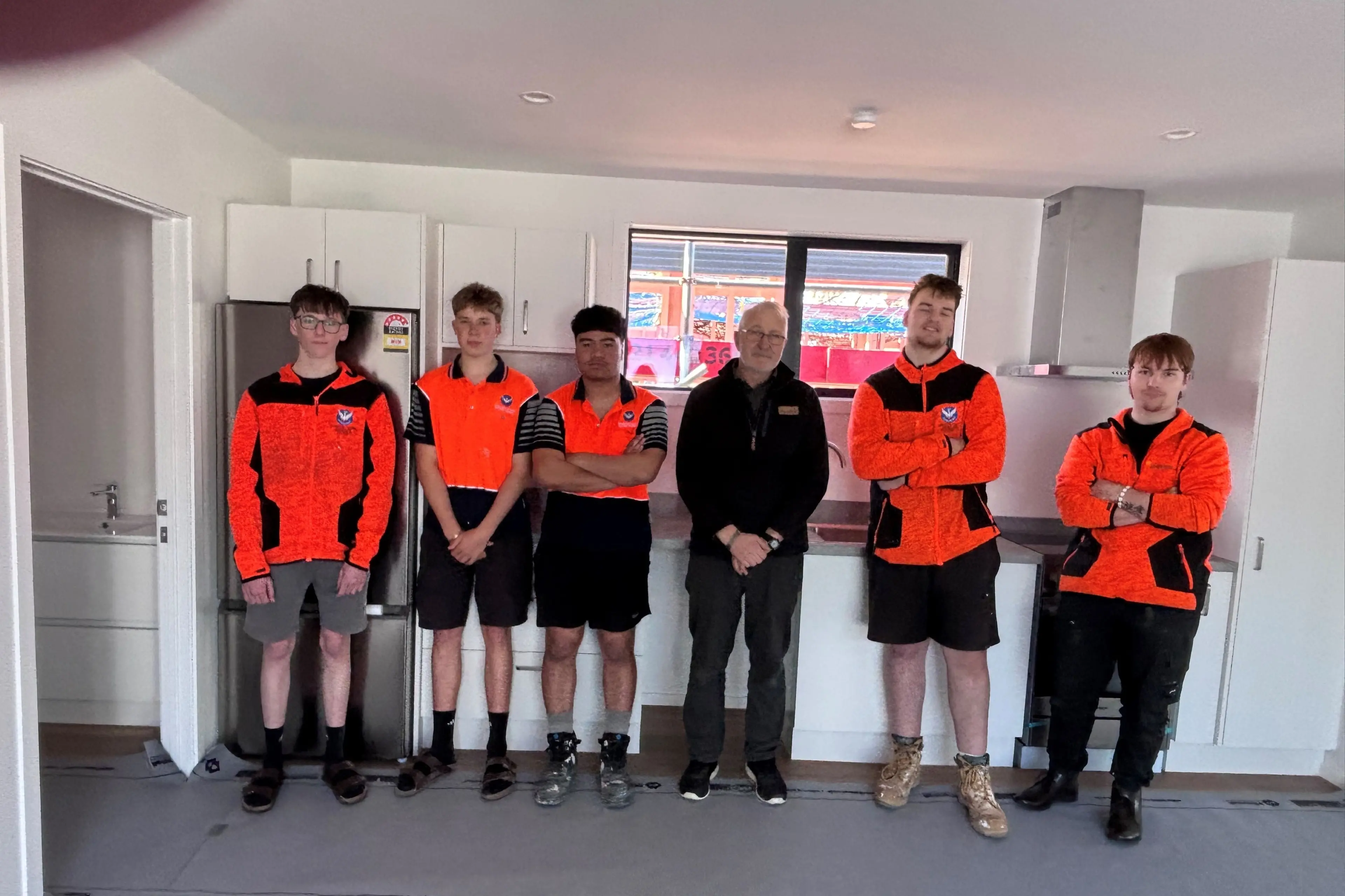 Construction students, from left, Harry Trott, 17, Riley Trotter, 17, Kymani-Cruz Pupuke, 18. teacher Brian Jones, Jacob Carr, 17, and Cace Aubrey, 18 in one of the finished two-bedroom homes. Photo: Heather Mackenzie