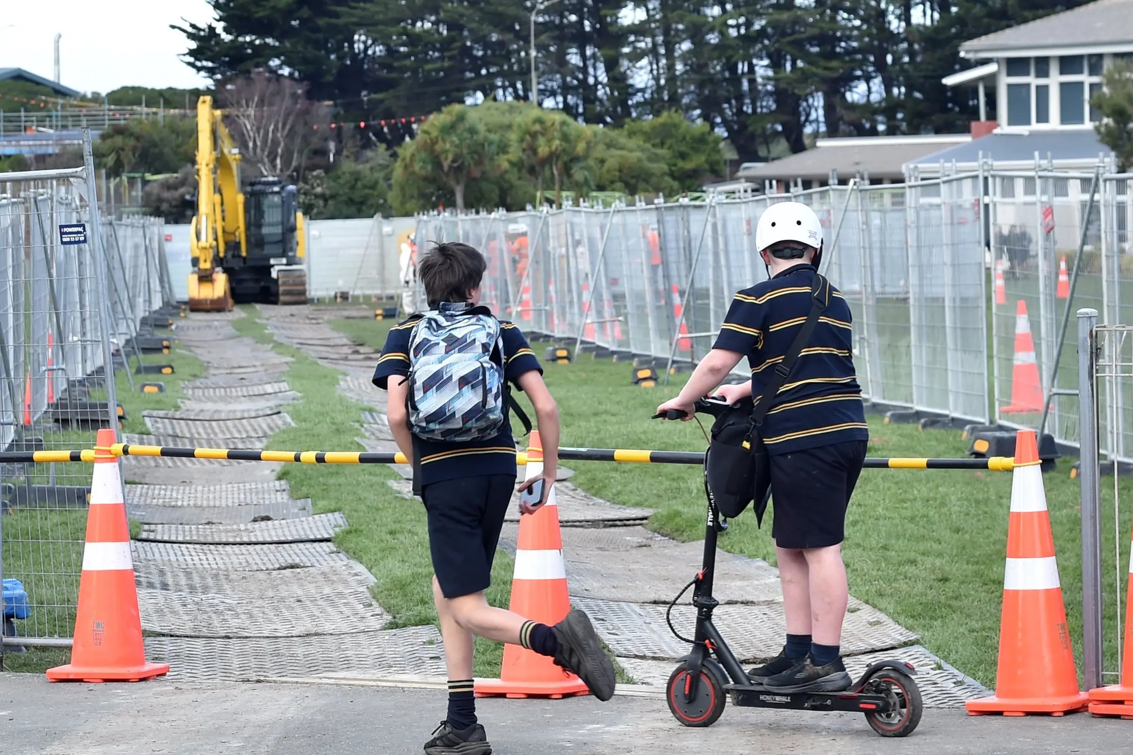 Passing Tahuna Normal Intermediate School pupils watch as contractors work on pipes underneath their school on Monday. Photo: Peter McIntosh