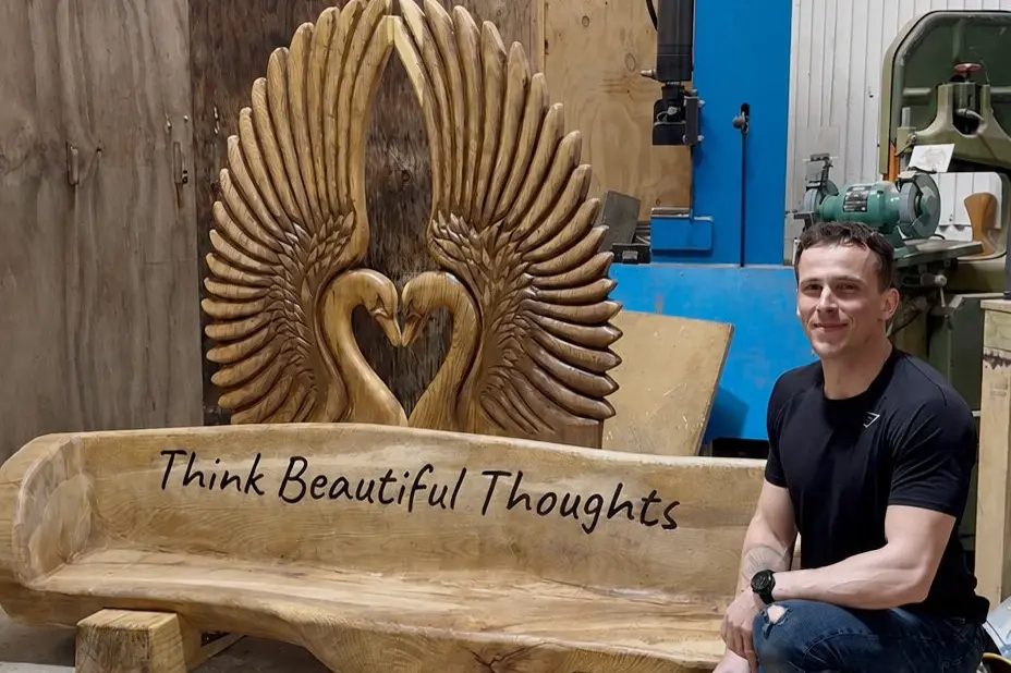 W\\u0101naka sculptor Justin Klar with his \"Think Beautiful Thoughts\" bench. Photo: Supplied