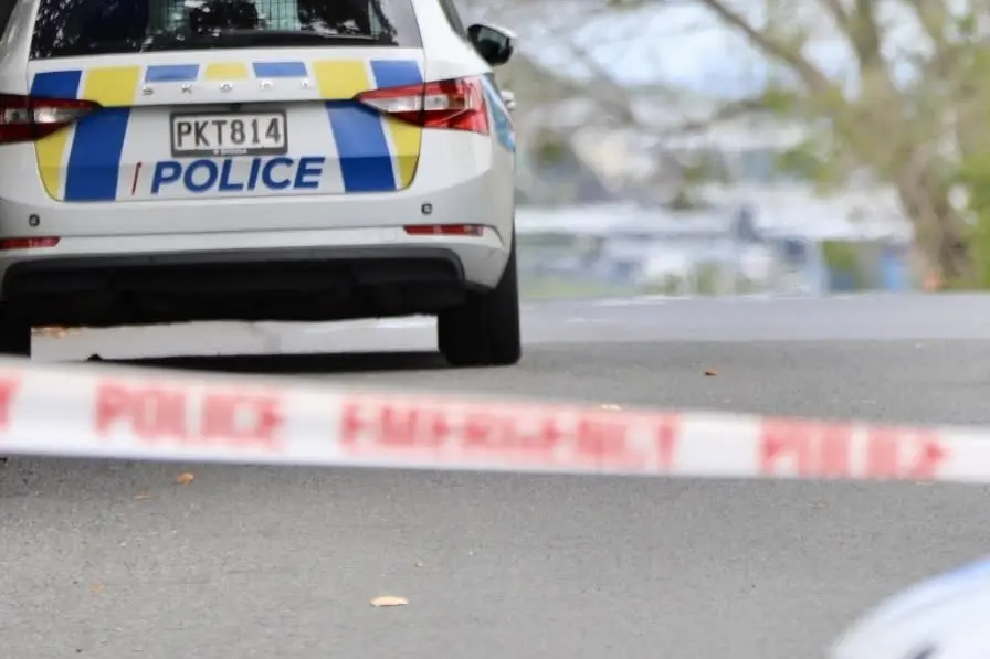 A police car seen behind a cordon as officers attend an incident.