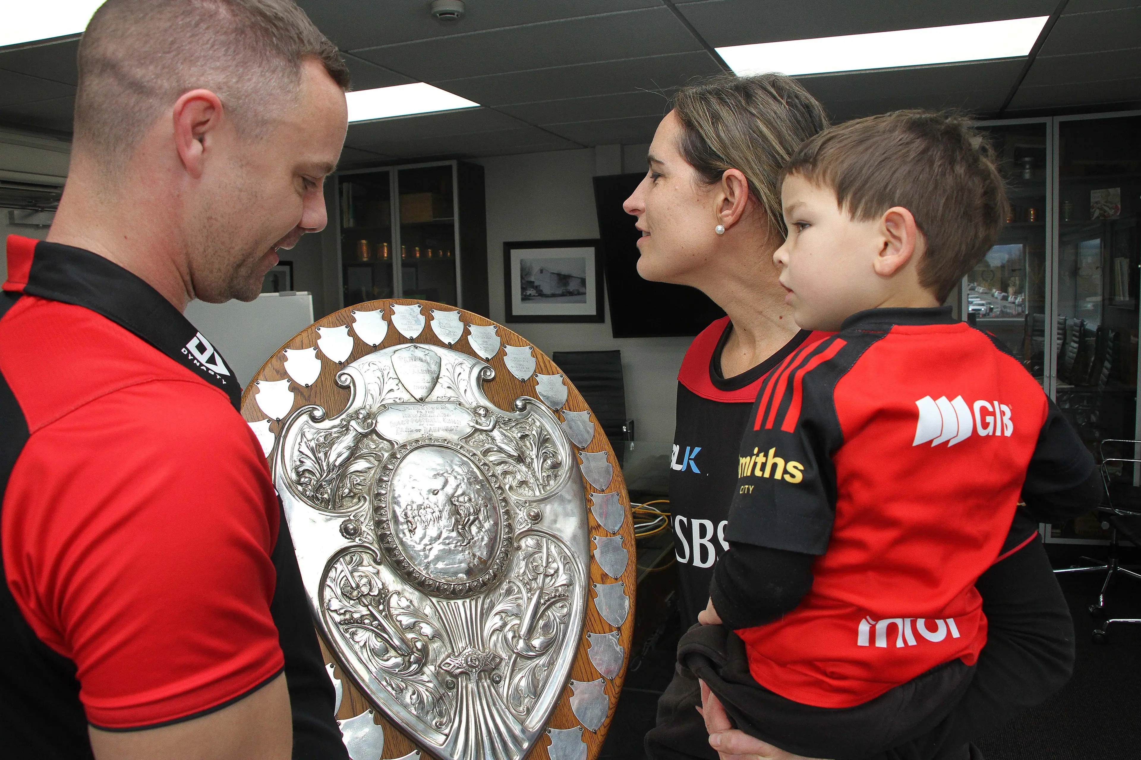 Close up with the Shield . . .Richie Frampton (3) and his mum Amy Frampton, get a close look at the Ranfurly Shield held by CRFU partnership manager Zac Topping, during a display of the shield at Luisetti Seeds Headquarters last week. Photo: John Cosgrove