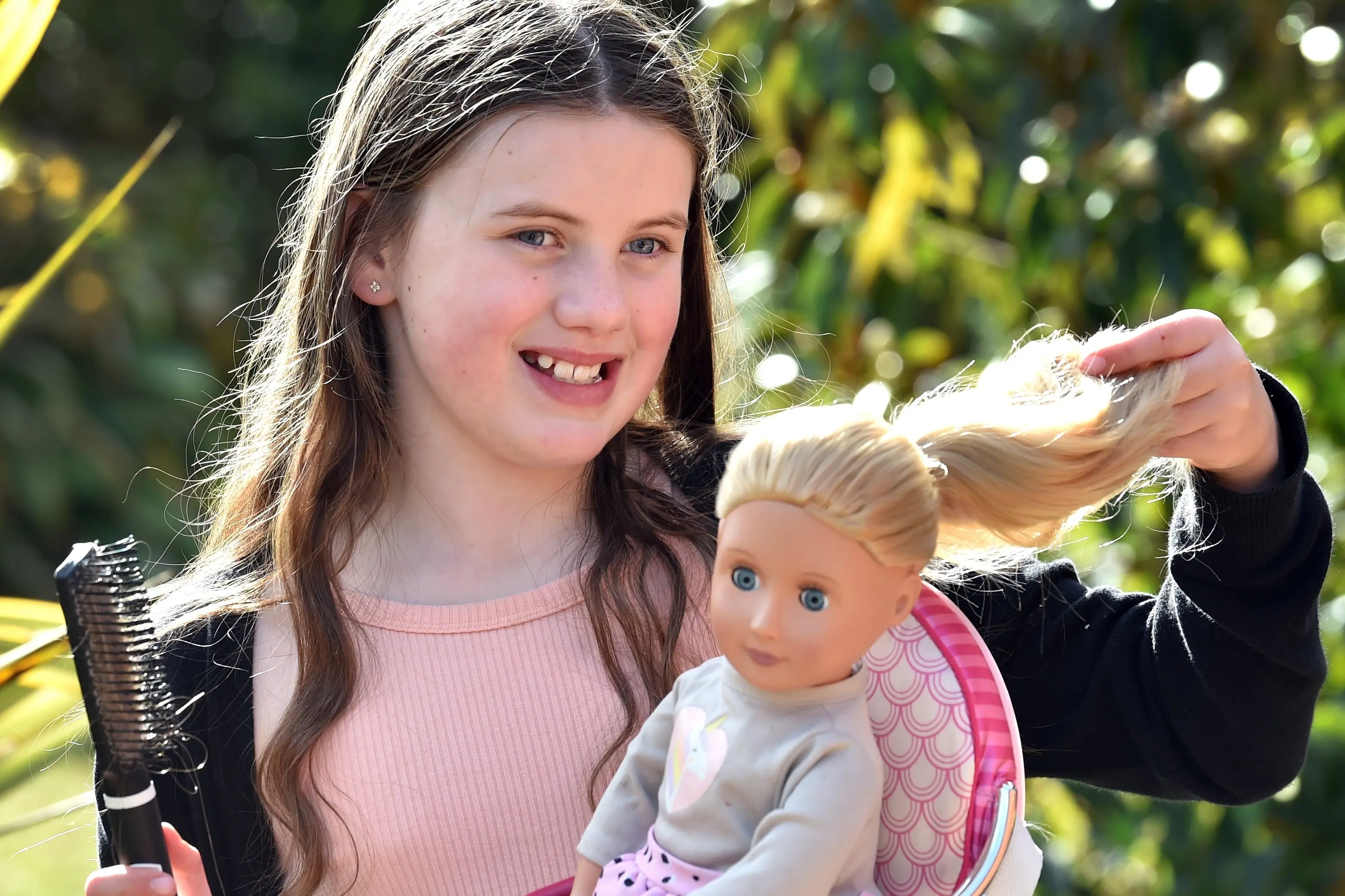 Budding Dunedin hairdresser Imogen Dench, 9, gives her friend\\'s doll Lola\\'s hair a brush through. Photo: Peter McIntosh