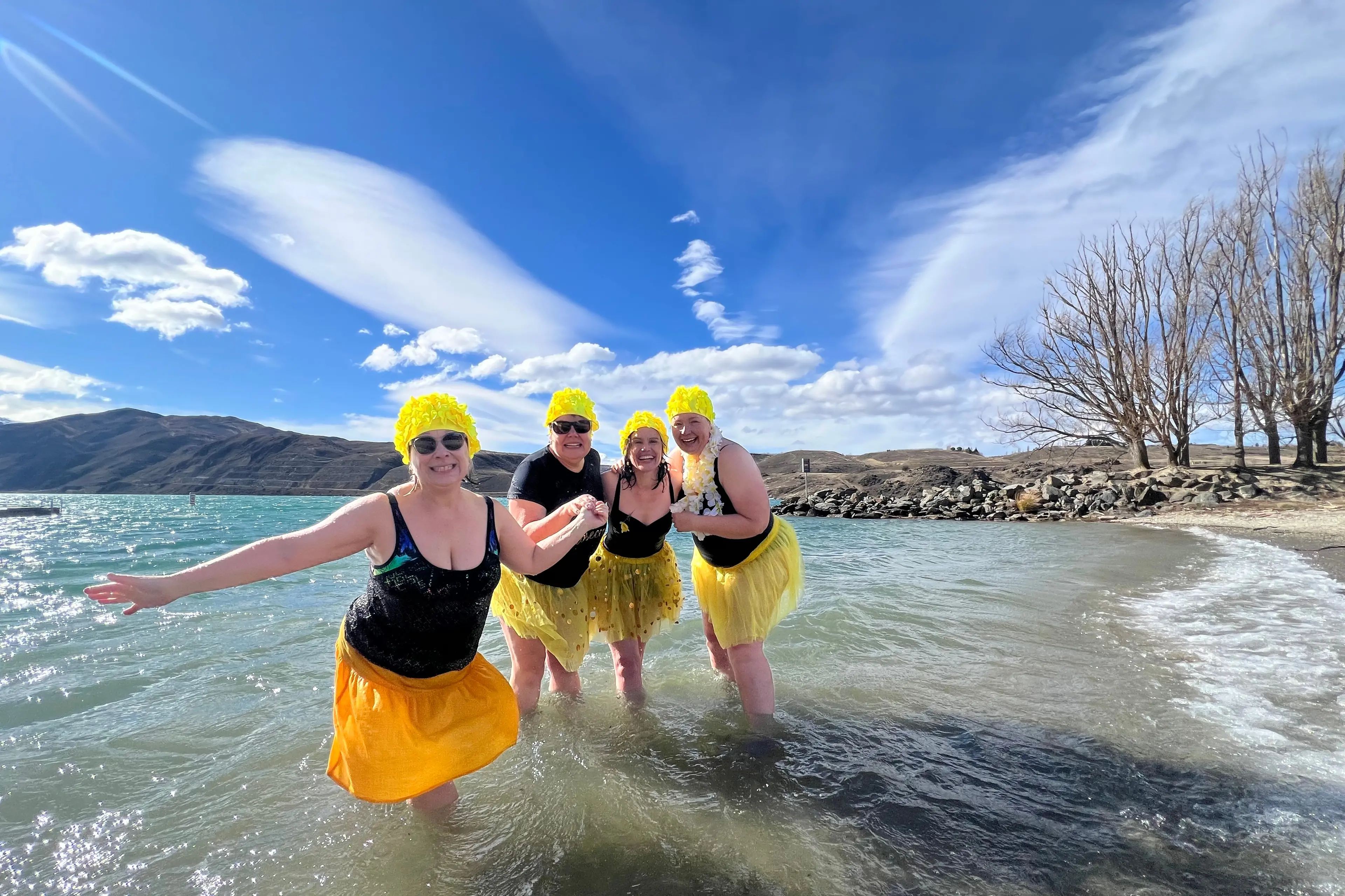 Daffy Dippers and friends (left to right) Bronwen Townsend, Jill Marsh, Maria De Cort and Christina Martin are all smiles after the cold plunge into Lake Dunstan for Cancer Society\\'s annual Daffodil Day. Photo: Carys Trotter