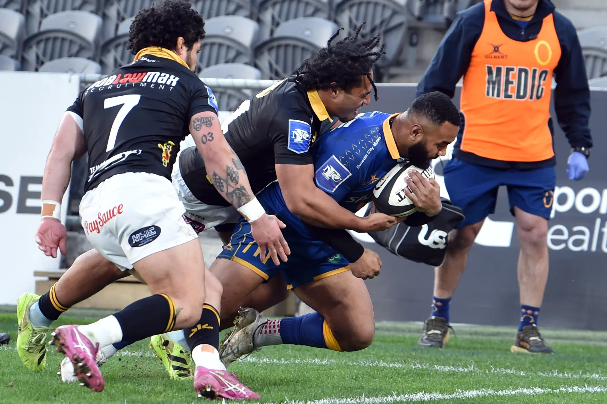 Otago winger Jona Nareki muscles over to score in the corner despite the effort of Wellington pair Isi Saumaki and  Du\\u2019Plessis Kirifi (left) at Forsyth Barr Stadium on Sunday. Photo: Peter McIntosh.