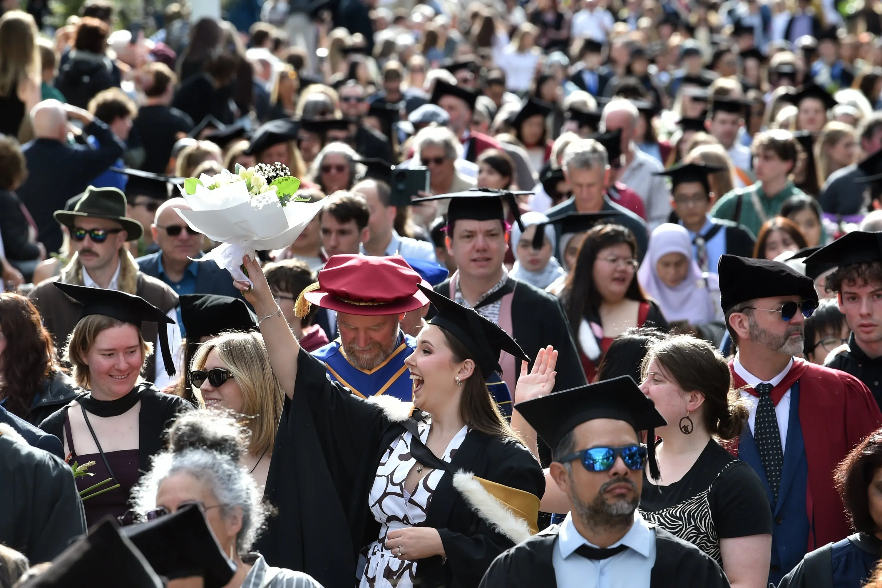 Graduates makes their way down George St on Saturday. Photo: Peter McIntosh