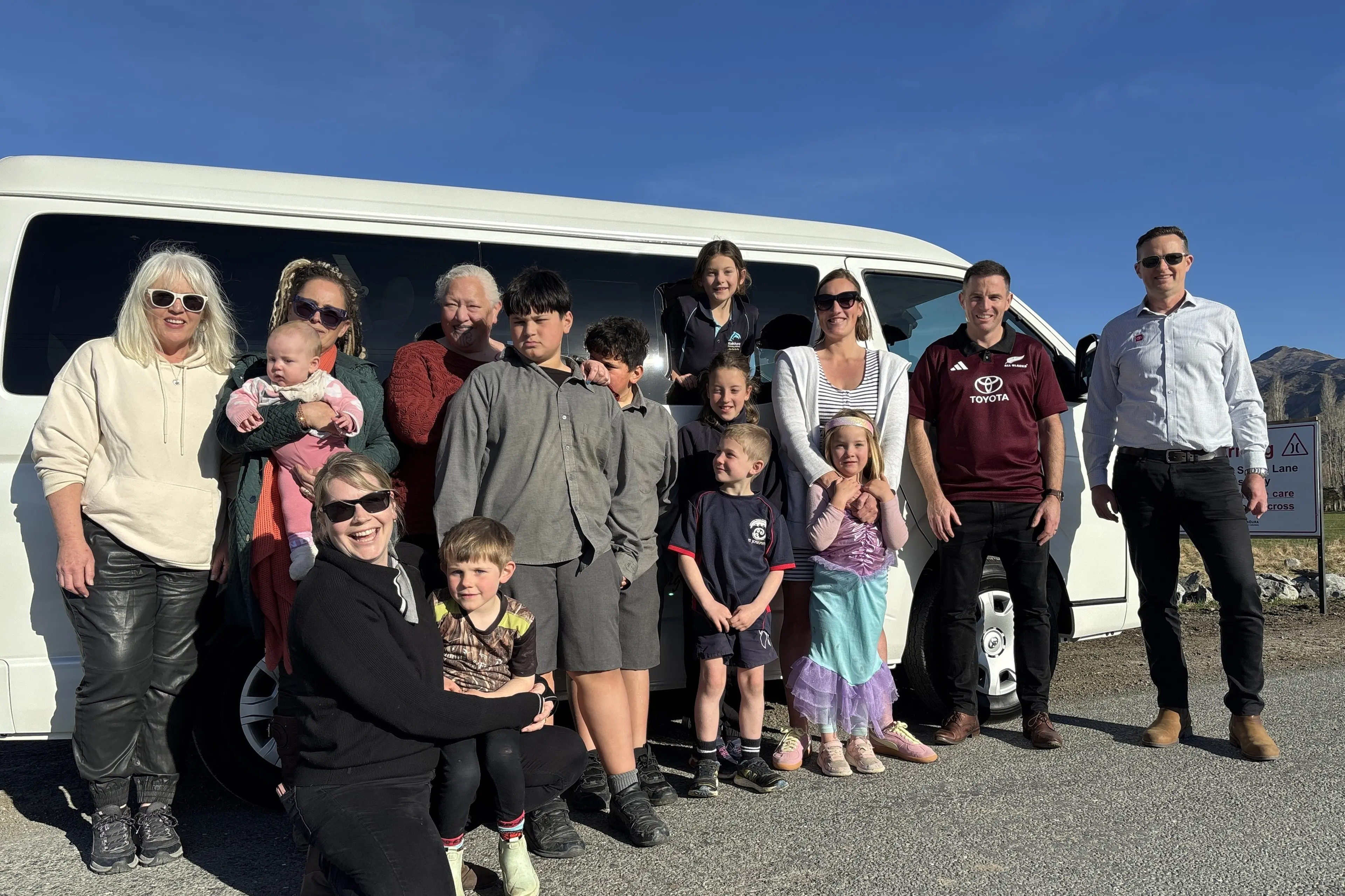 Ready for the school run . . . Kaik\\u014Dura District Council regulatory administration officer Fiona Buchanan (left), council recovery manager Jo York holding Bonnie Taylor (baby), Zoe Howden (kneeling) with her son Dalton Howden, Te R\\u016Bnanga o Kaik\\u014Dura chairperson Hariata Kahu, Horiszn and Shaden (boys in grey uniform), Tessa Taylor (head out the window), Indie Taylor, Weston Howden (front), Bub Taylor with Ria Taylor (front), Blenheim Toyota branch manager Cory Rowden (right) and chief executive Scott McDermid. Photo: Supplied by Blenheim Toyota