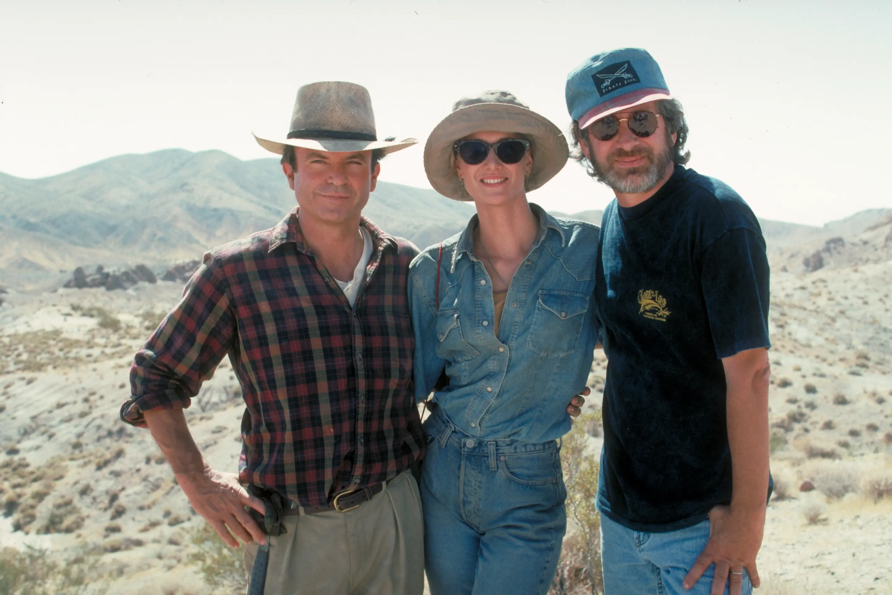 <p>Sir Sam Neill (left) with Laura Dern and Steven Spielberg on the set of their 1993 hit Jurassic Park. Photo: Getty Images</p>\\n