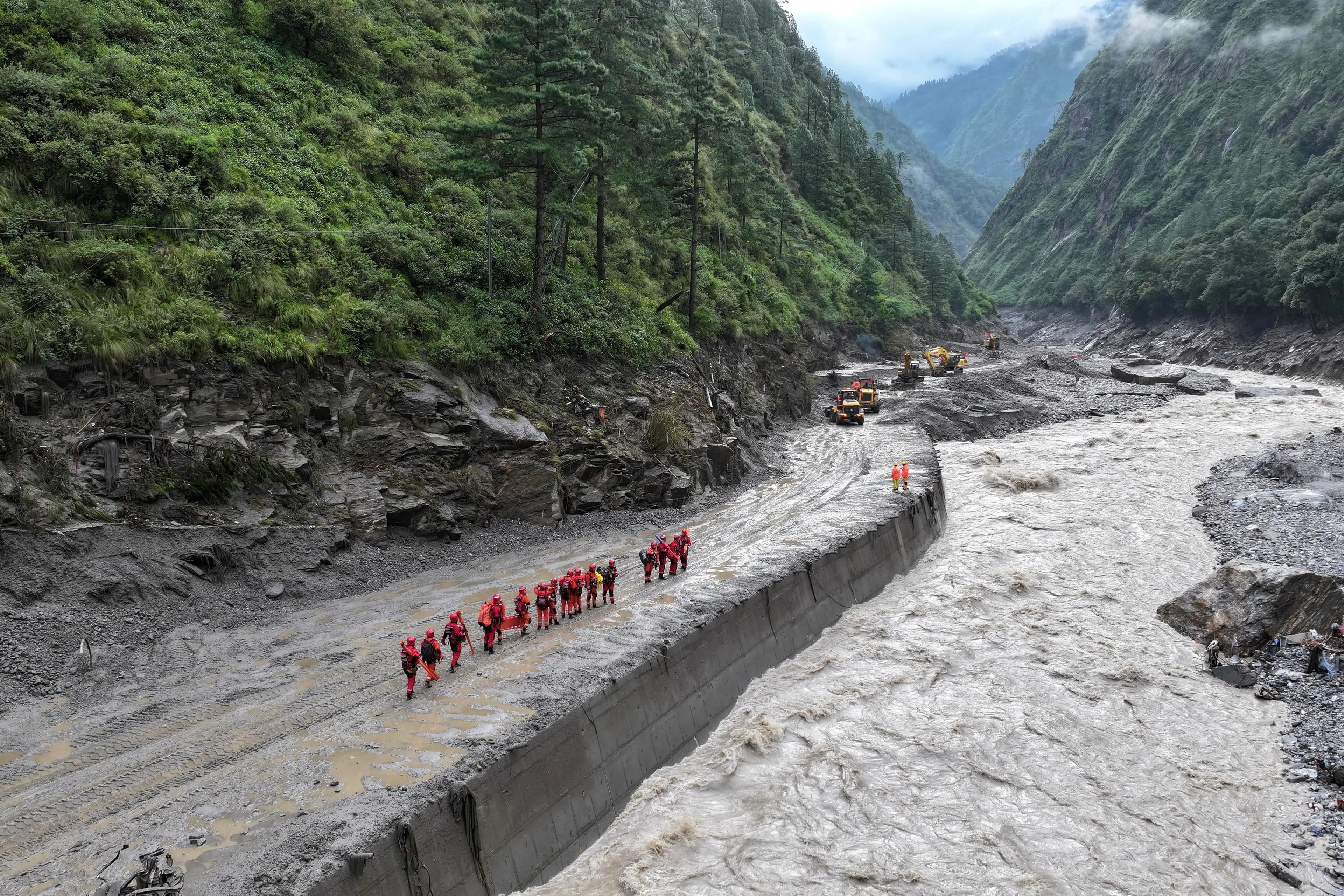 <p>A drone view of firefighters conducting search and rescue operations at a damaged road leading to Gyirong Port after a mudslide, in Gyirong county, Shigatse, Tibet Autonomous Region, China. Photo: cnsphoto via Reuters&nbsp;</p>\\n